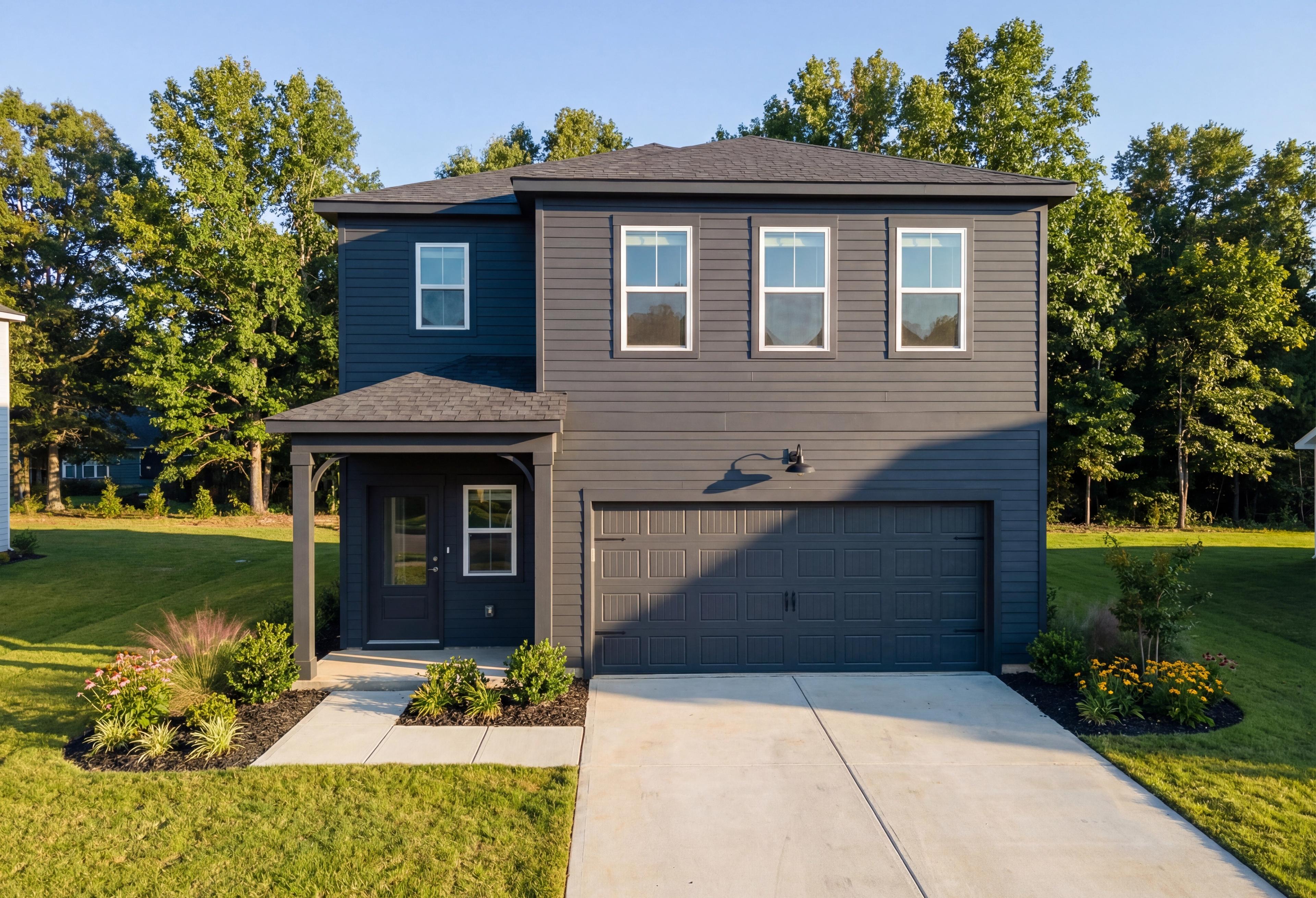 Modern two-story The Sinclair A elevation with dark gray siding, two-car garage, covered porch, and landscaped yard in New Market, Alabama