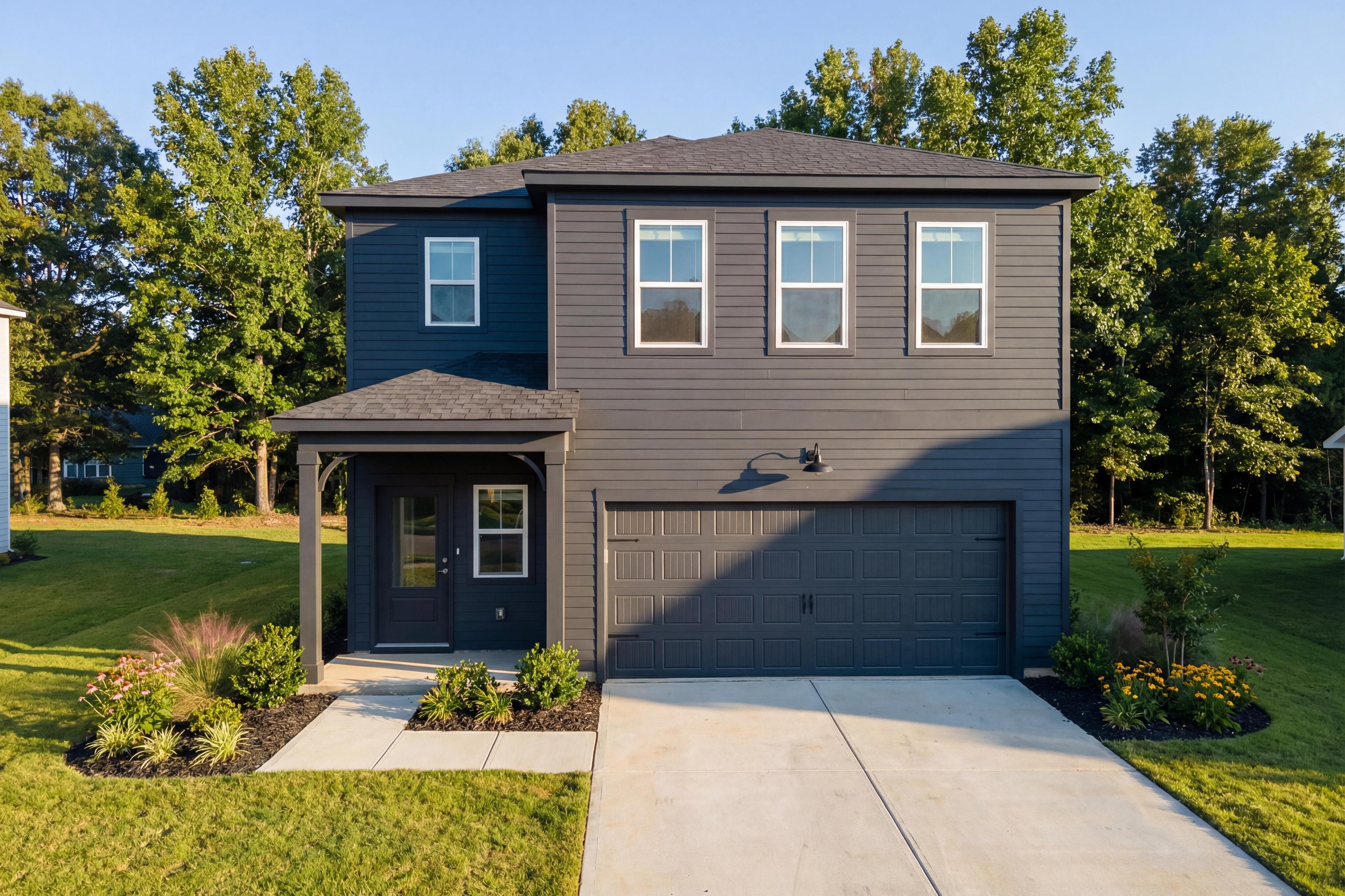 Modern two-story The Sinclair A elevation with dark gray siding, two-car garage, covered porch, and landscaped yard in New Market, Alabama