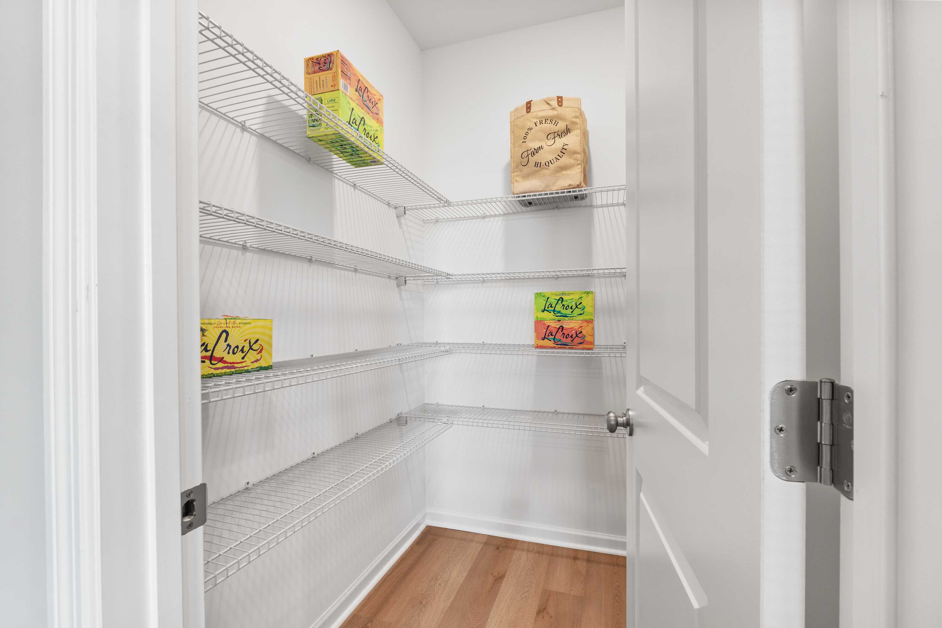 Spacious walk-in pantry with wire shelving stocked with Cheerios boxes at The Meadows at Hampton Cove, Owens Cross Roads AL