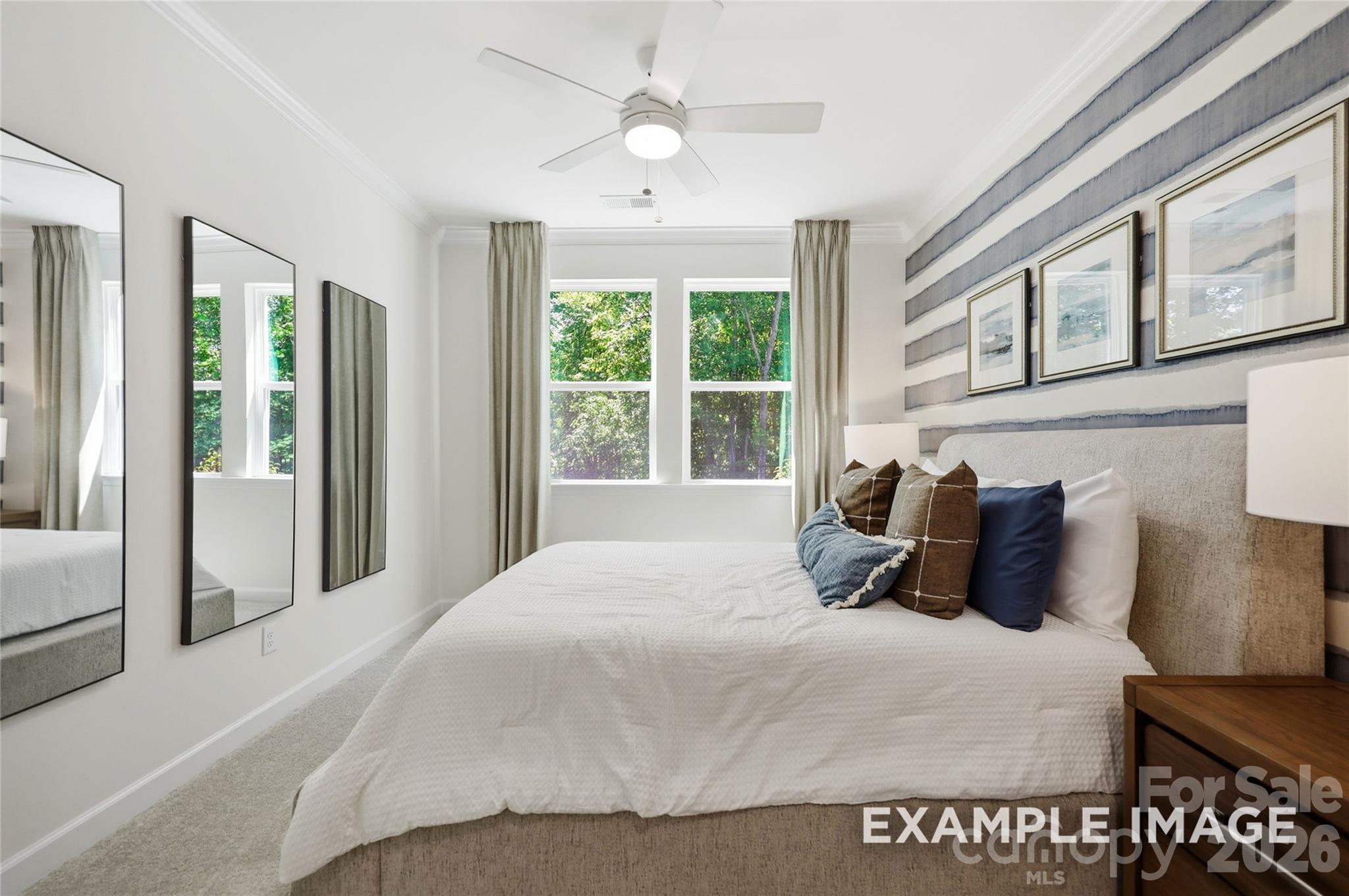 Bright bedroom with striped accent wall and ceiling fan in Davidson Homes The Aspen B, Windgate, Mooresville, NC