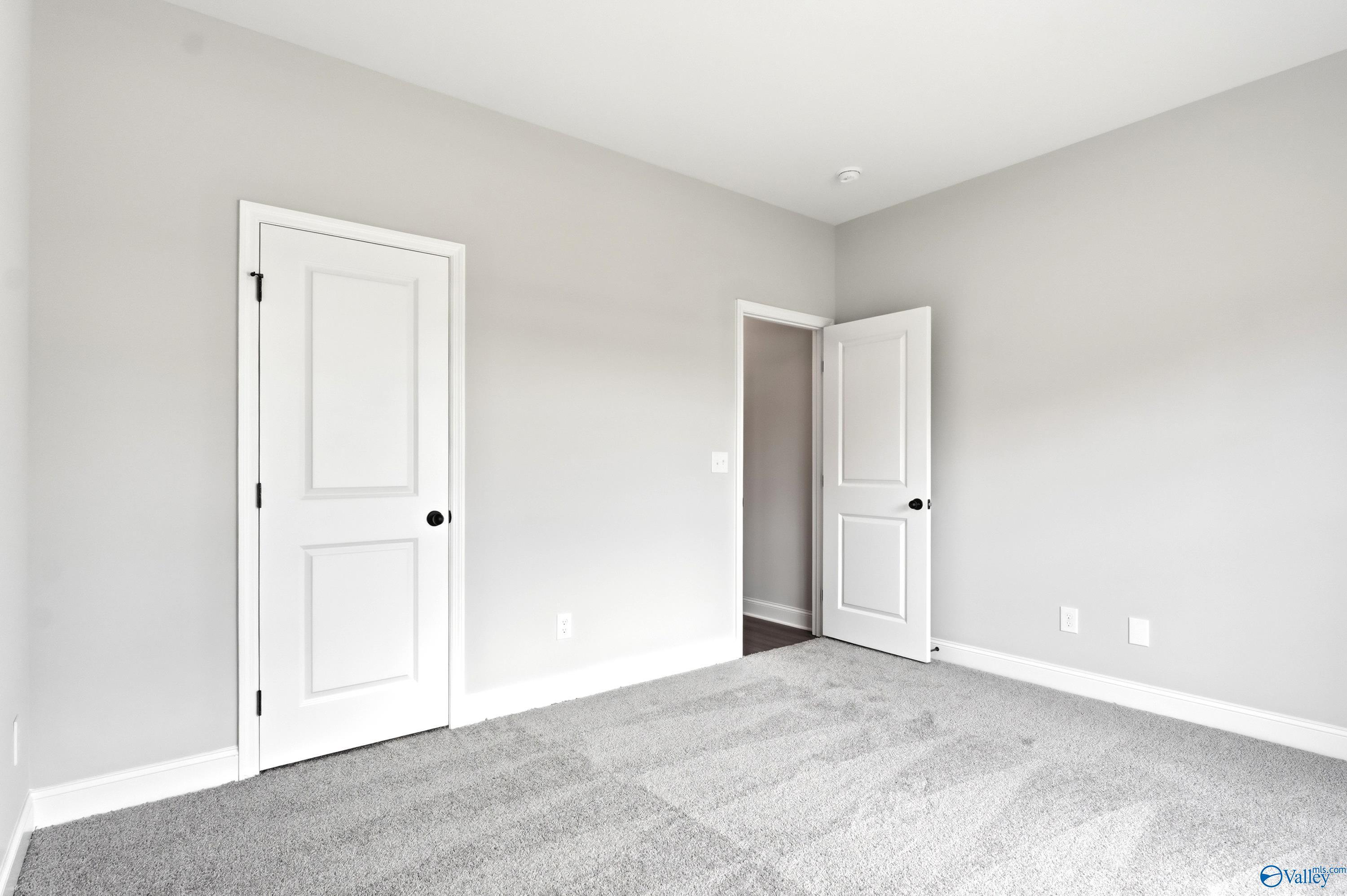 Bright, neutral bedroom with plush carpeting in The Daphne C floor plan by Davidson Homes in Flint Meadows, New Market.