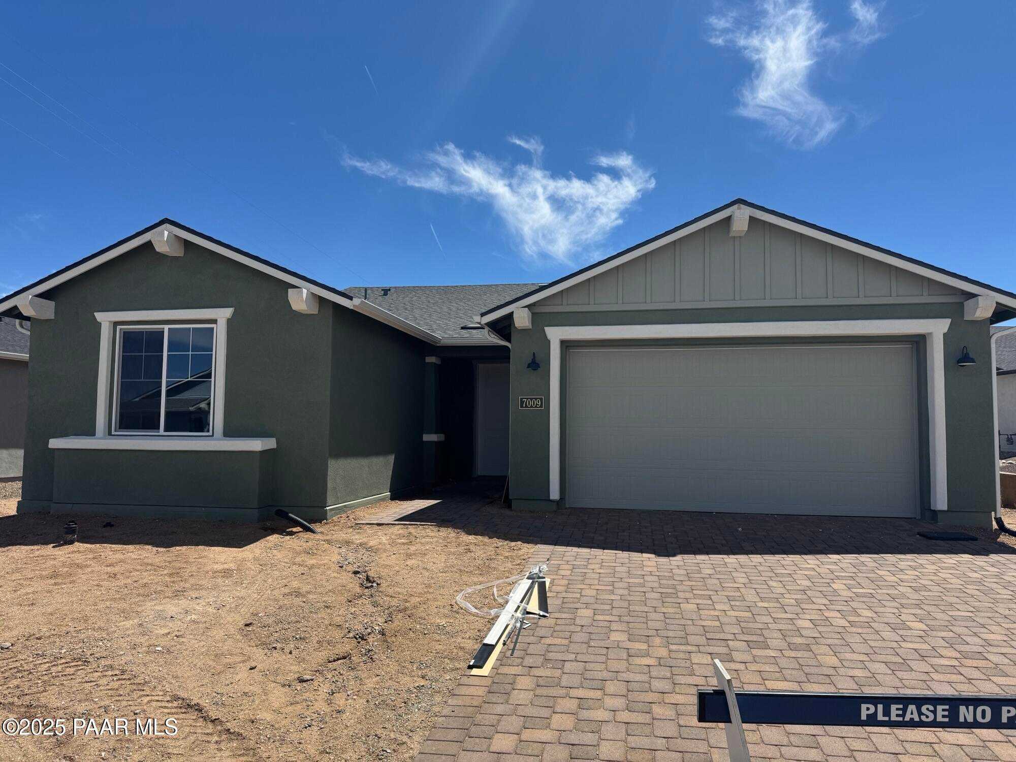 Modern gray single-story home with 3-car garage, white trim, and paver driveway in Westwood, Prescott, Arizona - Davidson Homes Sheridan II B