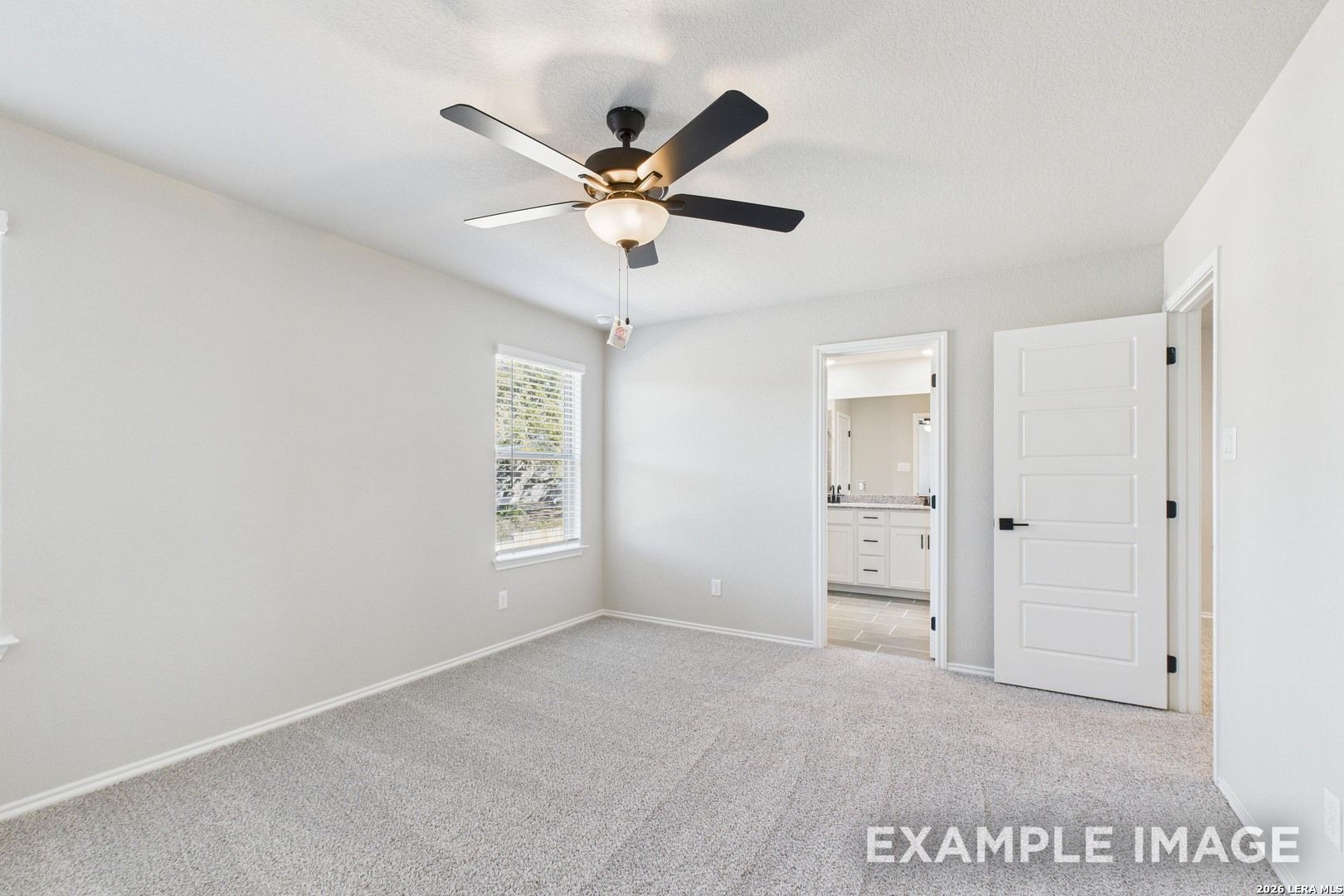 Bright bedroom with ceiling fan and en-suite bathroom in The Charlotte B floor plan by Davidson Homes in San Antonio, TX.