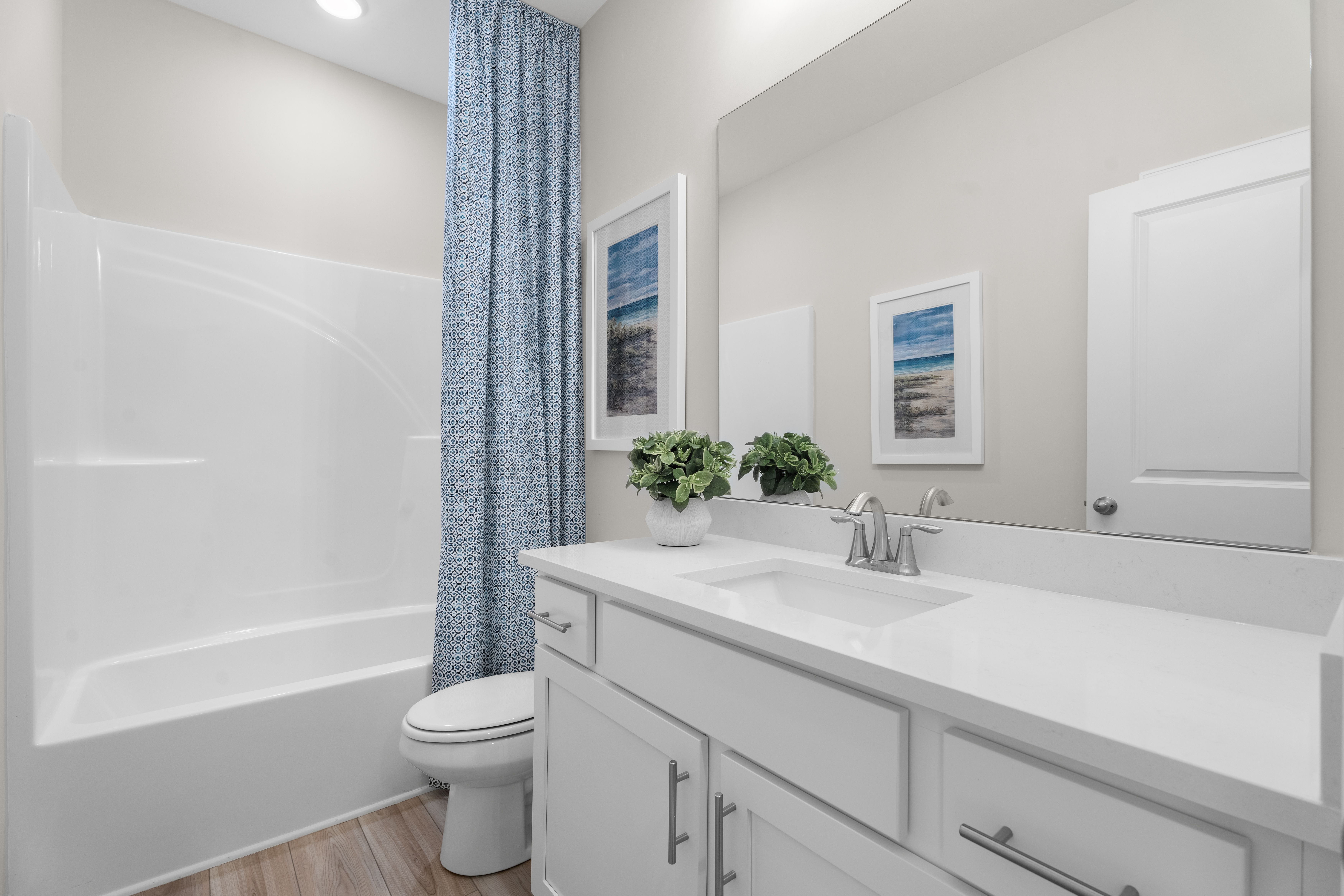 Secondary bathroom with large countertop, single sink, bathtub shower combo, toilet
