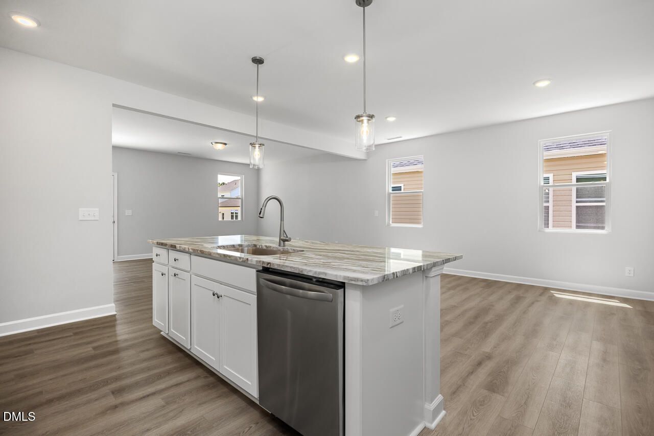 Modern kitchen island with granite countertops in The Adalynn A floor plan, Gregory Village, Lillington, North Carolina.