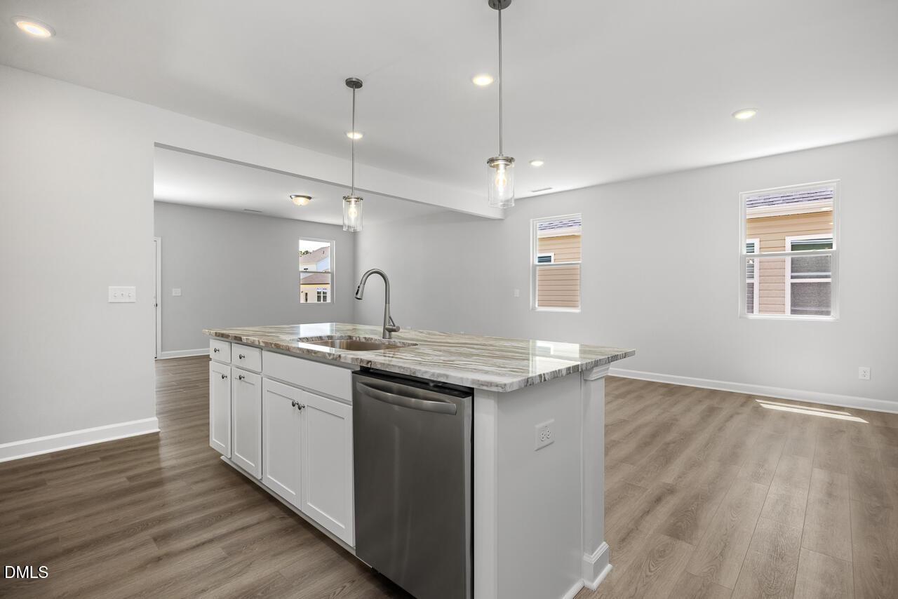 Modern kitchen island with granite countertops in The Adalynn A floor plan, Gregory Village, Lillington, North Carolina.