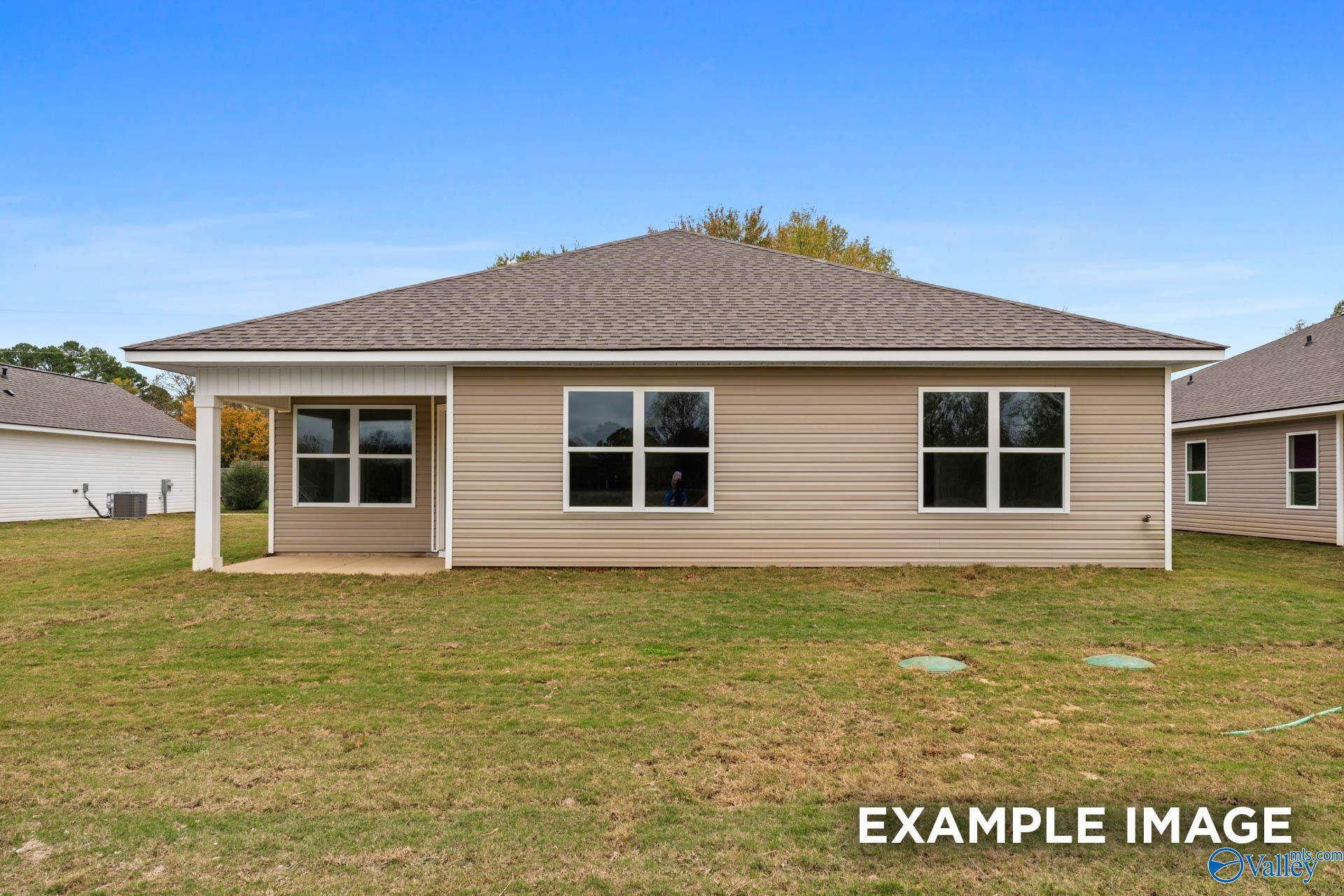 Rear view of The Daphne V 4-bedroom home by Davidson Homes with covered patio, large windows, and grassy yard in Chapel Hill, Athens, Alabama