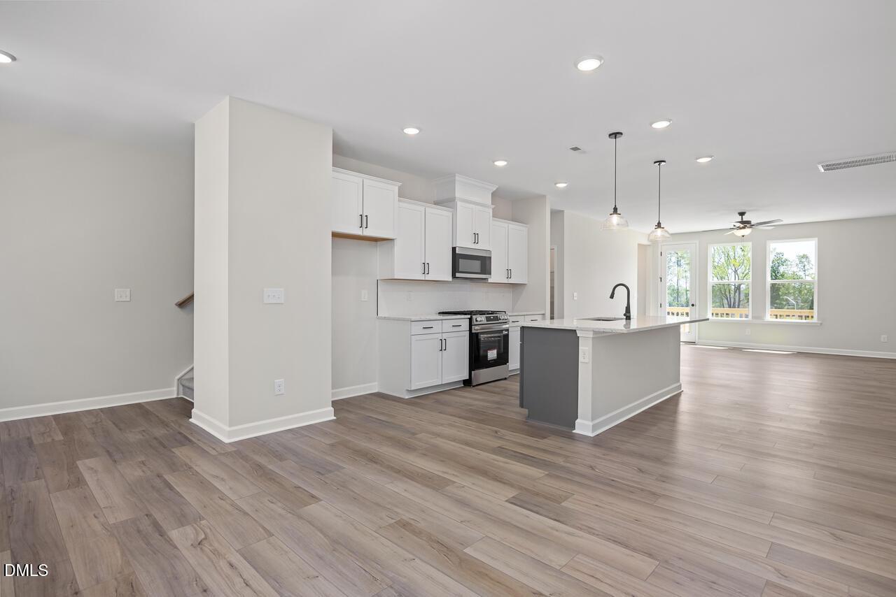 Open-concept kitchen with island and white cabinetry in The Mitchell floor plan at Camden Park, Knightdale, North Carolina.