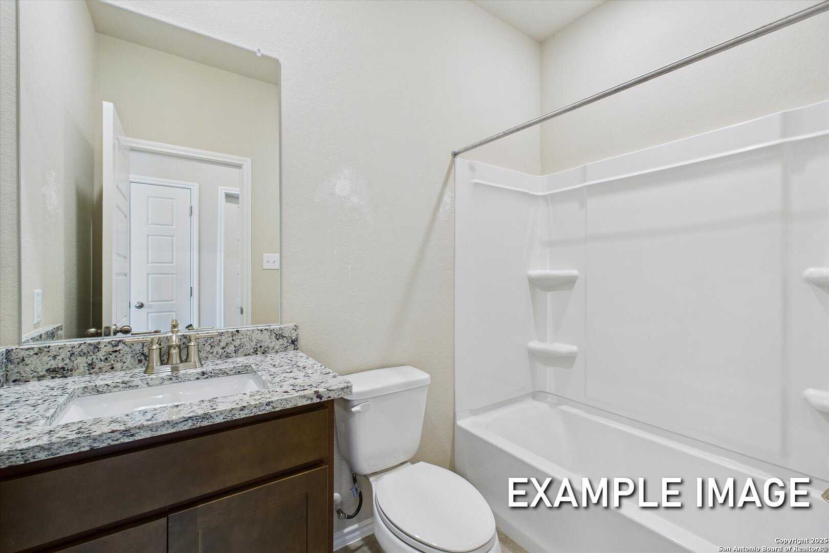 Modern guest bathroom with granite vanity, tub-shower combo, white surround in Davidson Homes The Comal B, San Antonio