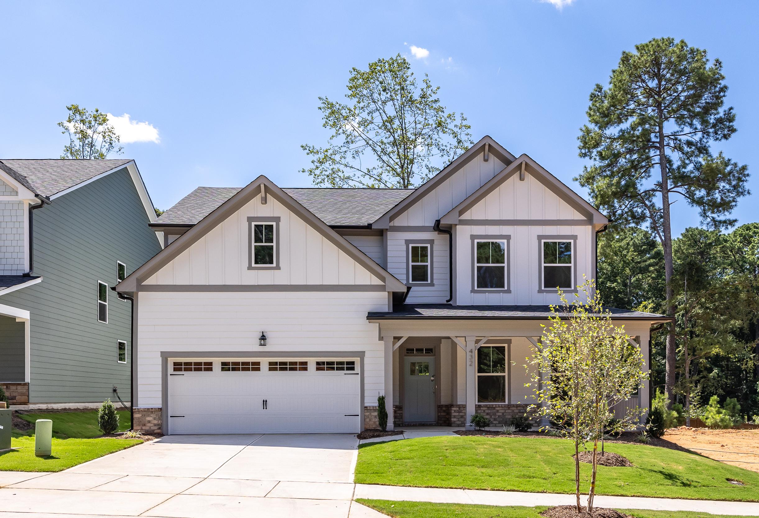 The Hickory II E 2-story home elevation by Davidson Homes with brick vinyl exterior, 2-car garage, front porch in Holly Springs NC