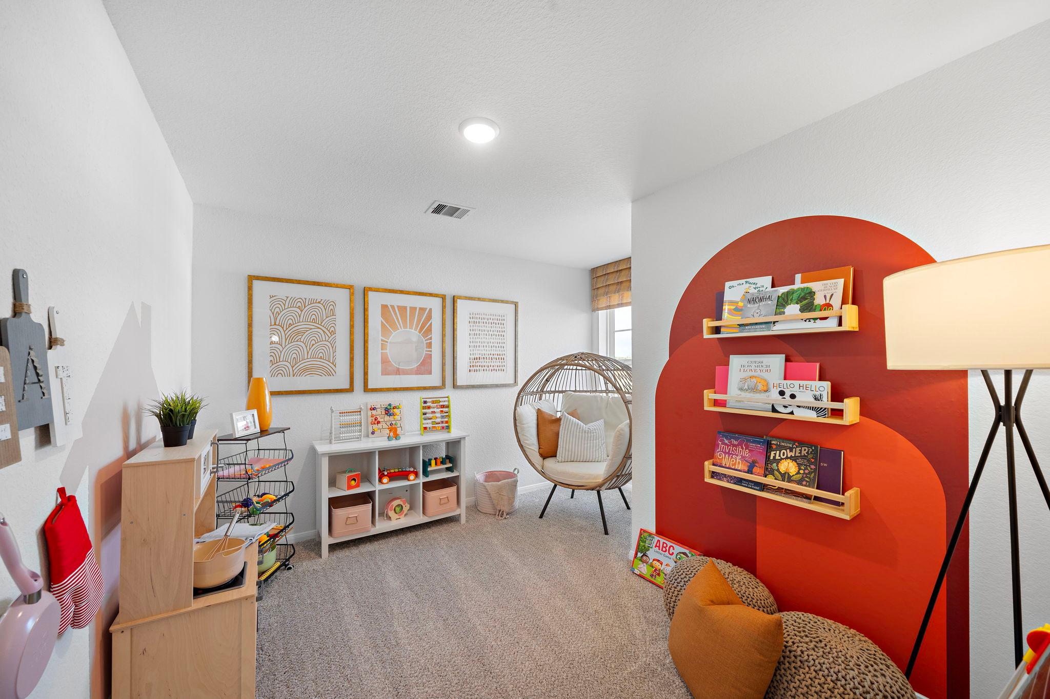 Cozy kids playroom at The Villages at WestPointe in Dayton Texas with toy kitchen bookshelves and hanging chair