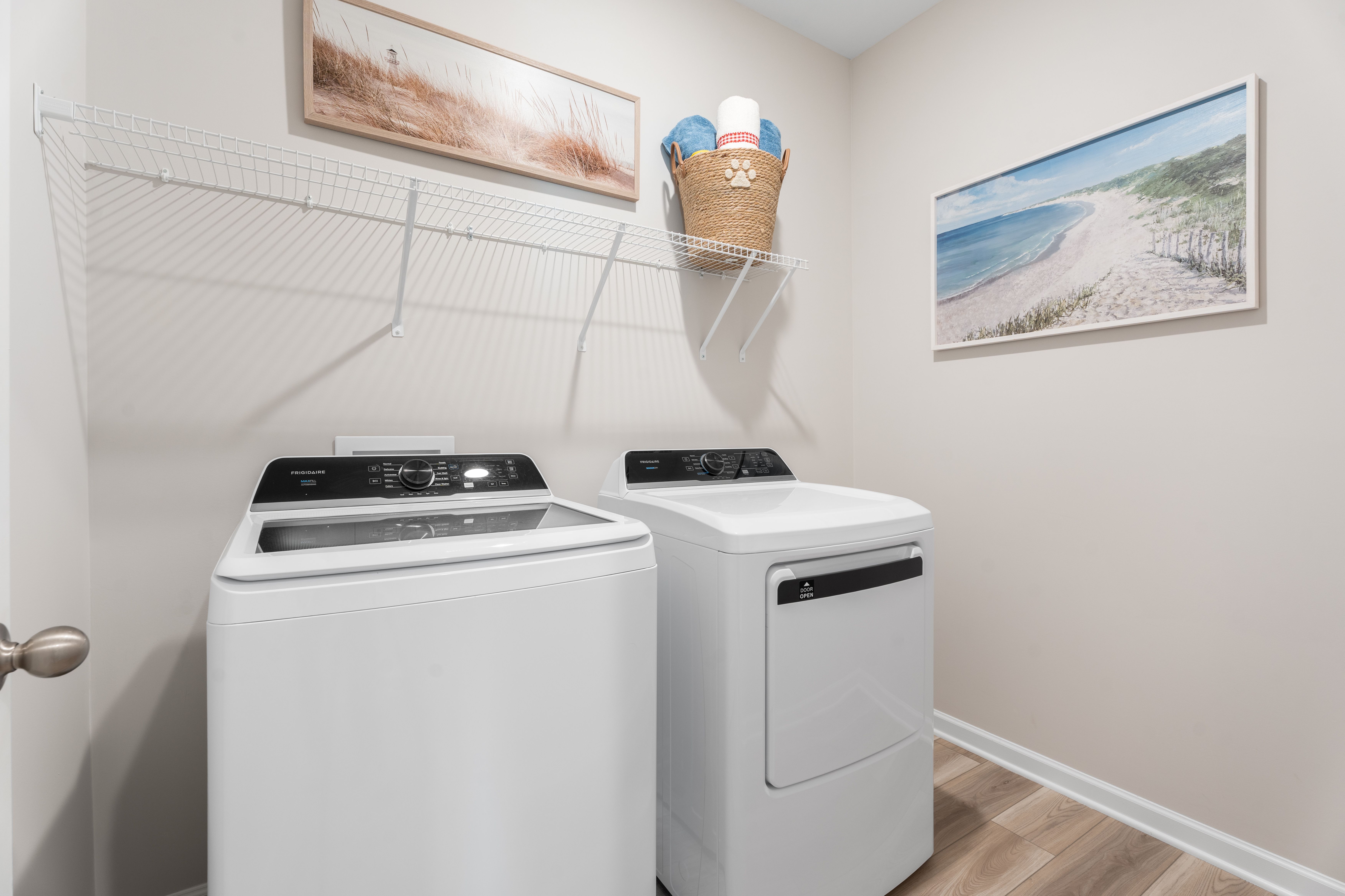 Laundry room with washer/dryer, shelving and hanging art