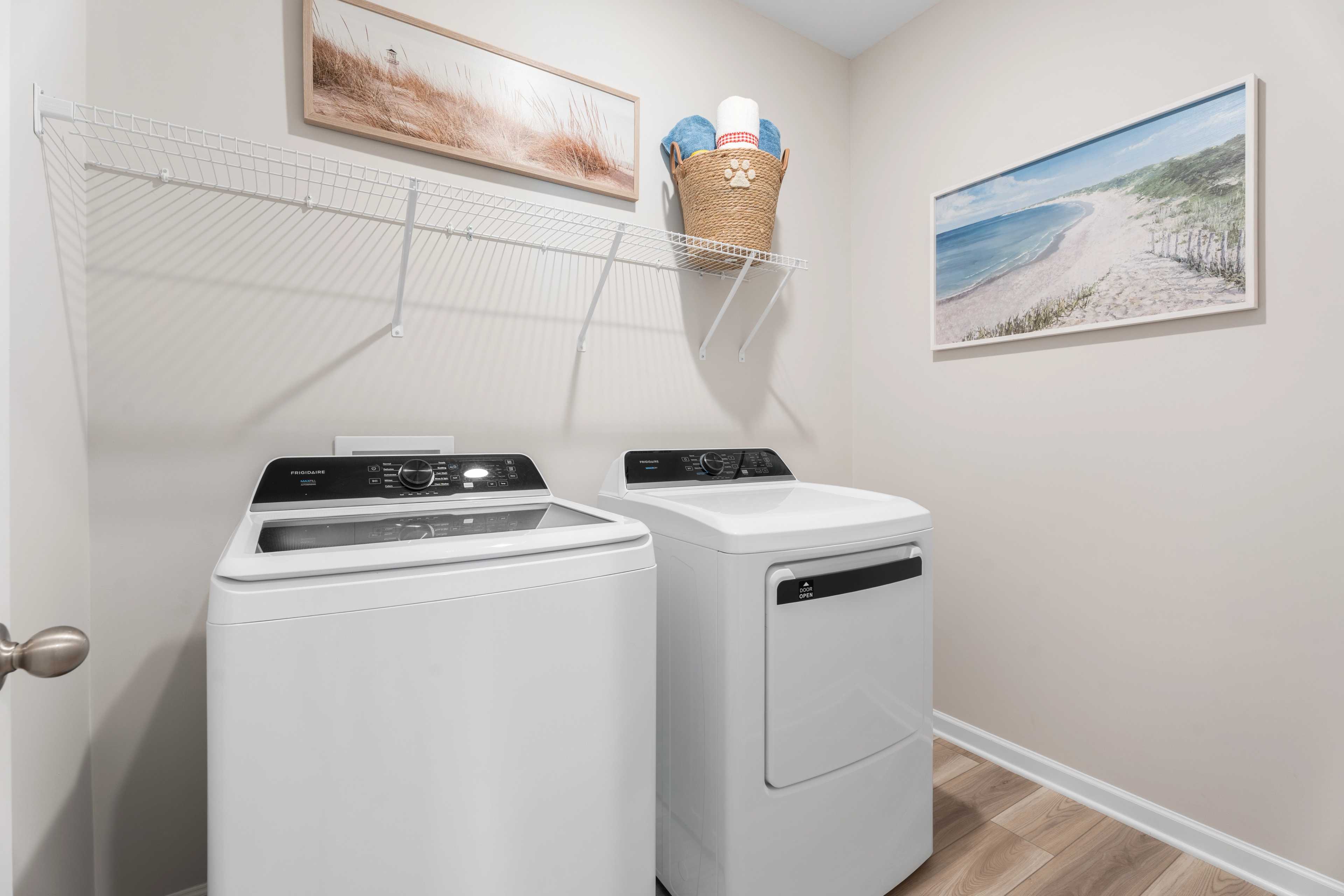 Laundry room with washer/dryer, shelving and hanging art
