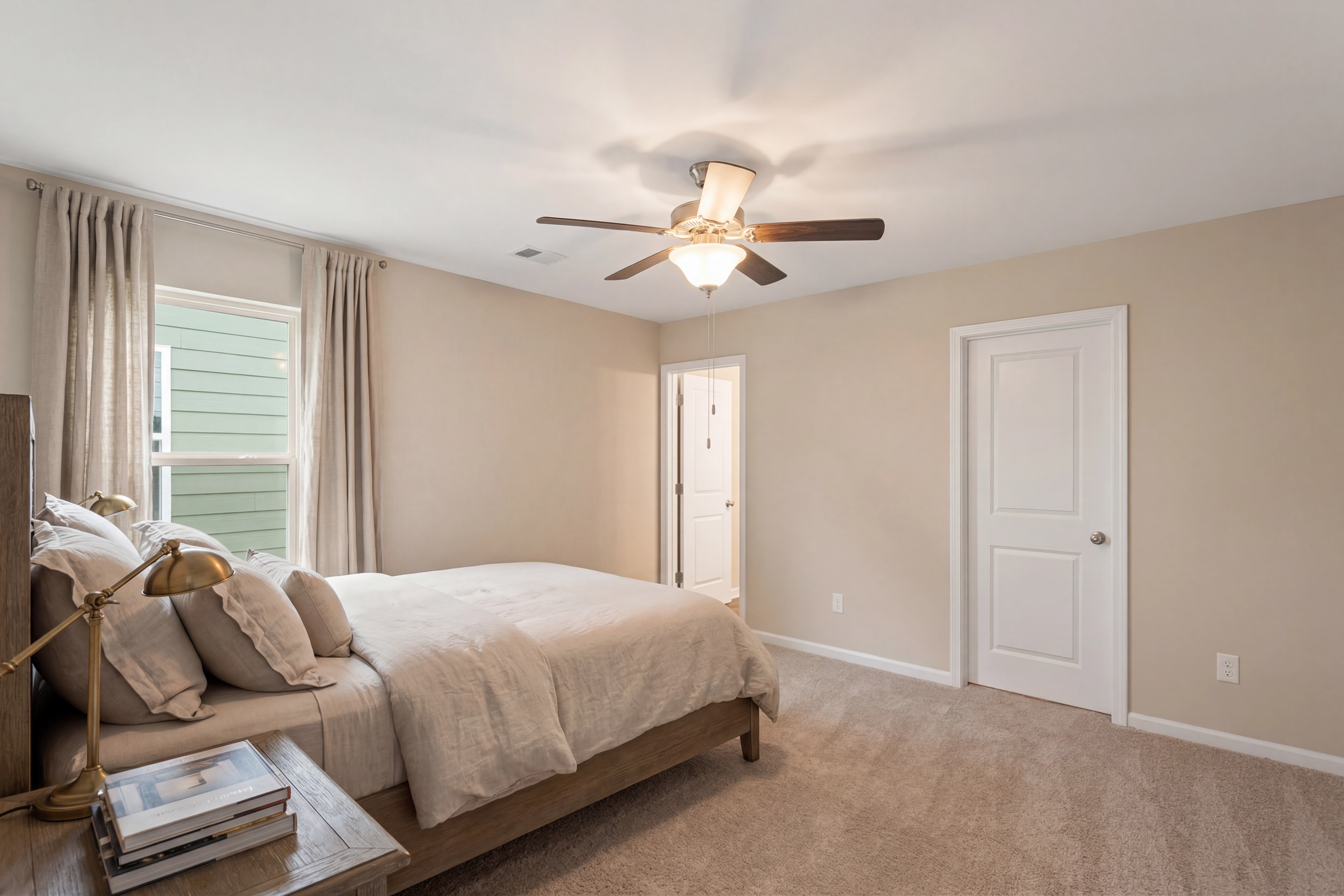 Cozy bedroom interior at Summer Vineyard in Phenix City AL with neutral beige walls, queen bed, ceiling fan, and window views