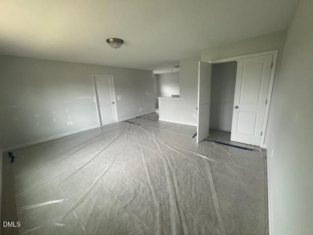 Spacious unfinished bedroom with protective floor covering in The Ash B floor plan at Retreat at North Main, Lillington, NC.