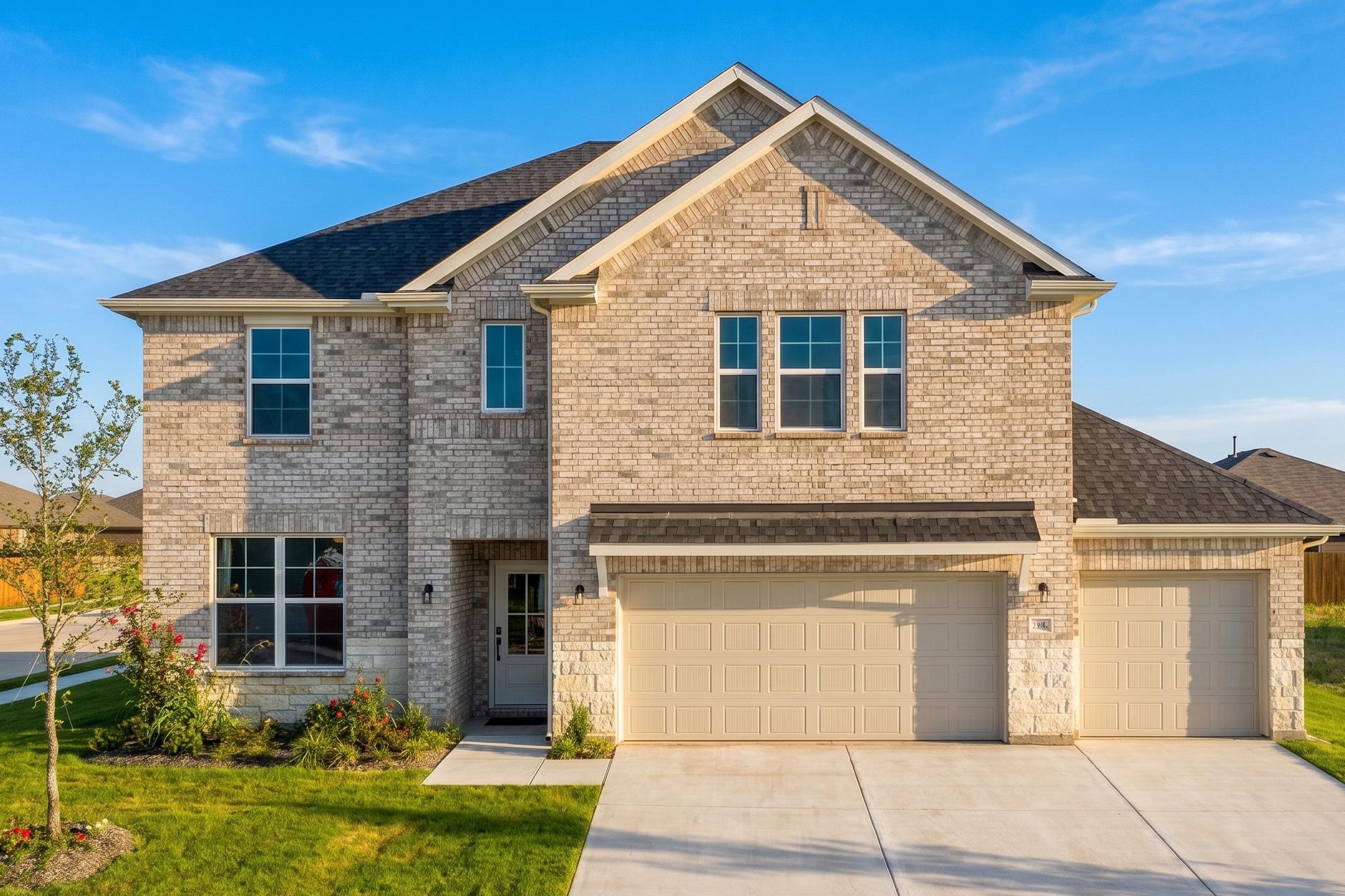 2-story home with a 3-car garage, light colored brick and stone
