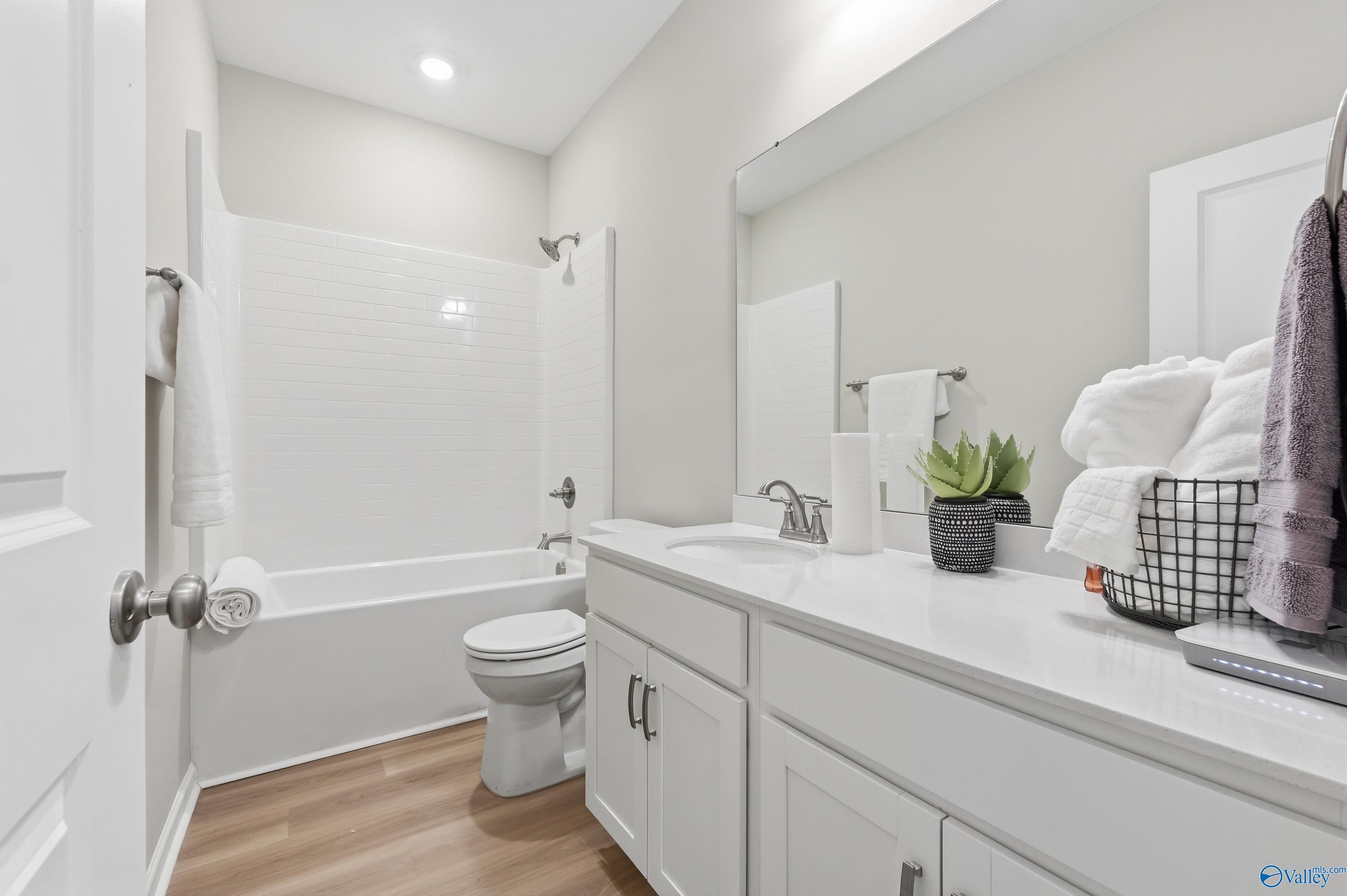 Modern bathroom with white subway tile shower, soaking tub, single vanity and neutral tones in Davidson Homes The Polaris, Fayetteville, TN