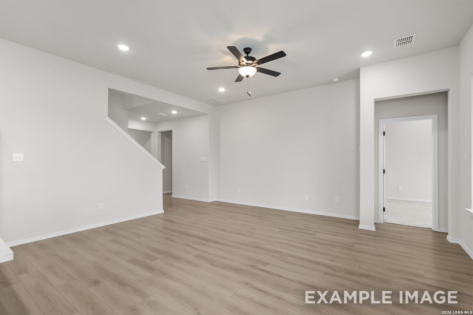 Bright open-concept living area with wood-style flooring in The Sequoia C floor plan by Davidson Homes, San Antonio, TX.