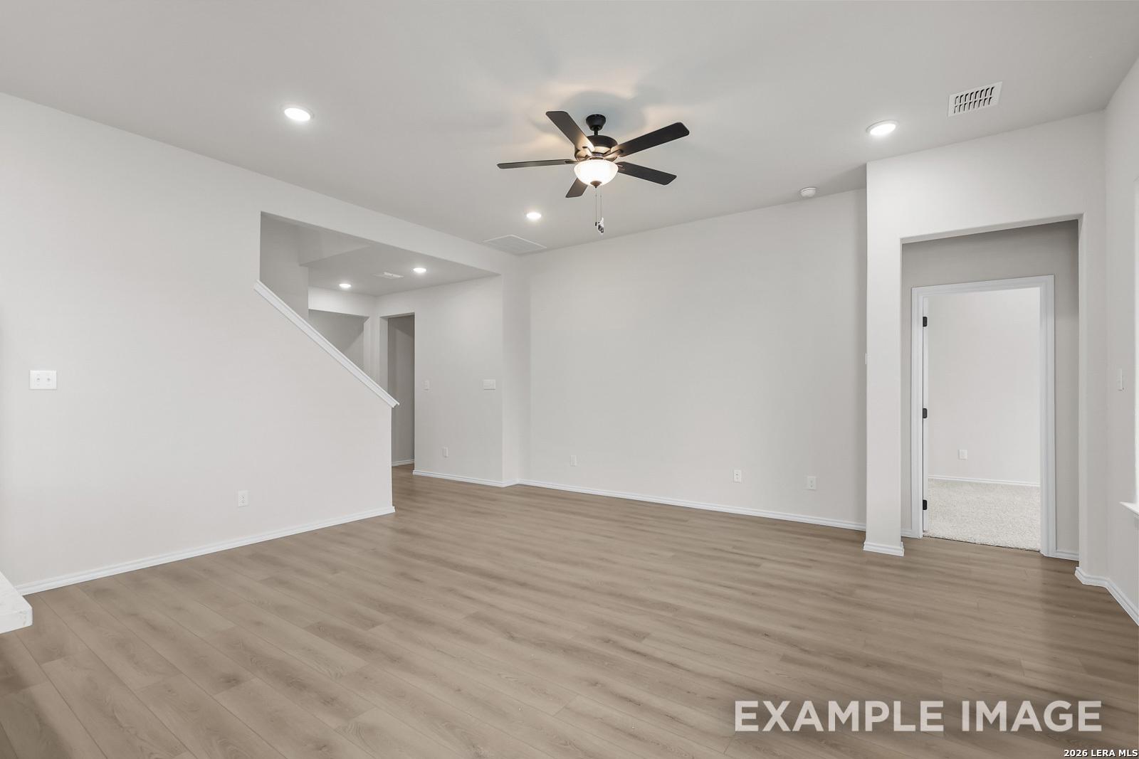 Bright open-concept living area with wood-style flooring in The Sequoia C floor plan by Davidson Homes, San Antonio, TX.