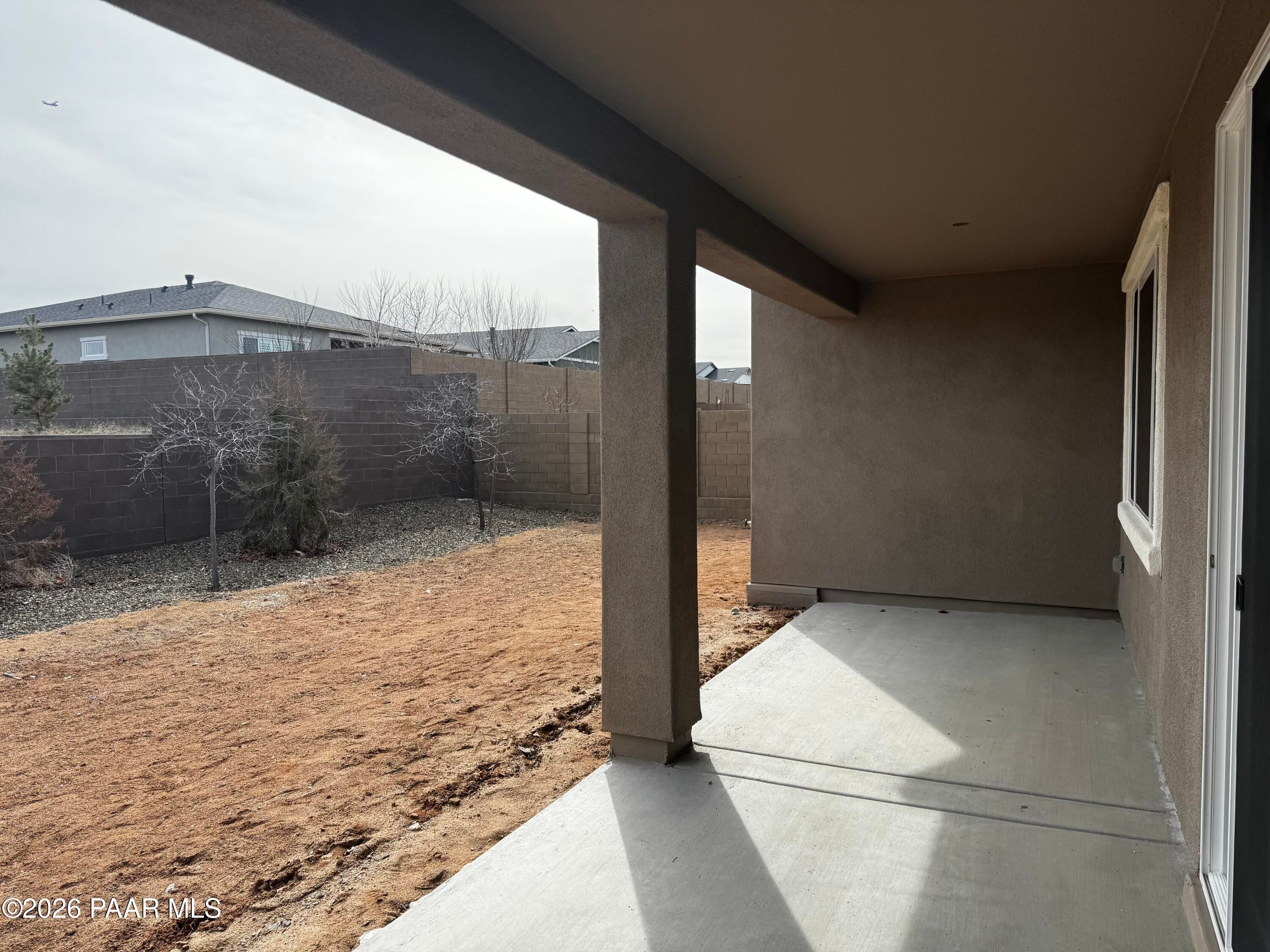 Covered patio with stucco walls, gravel backyard, and block fence in Davidson Homes The Durango II B, Westwood, Prescott, Arizona