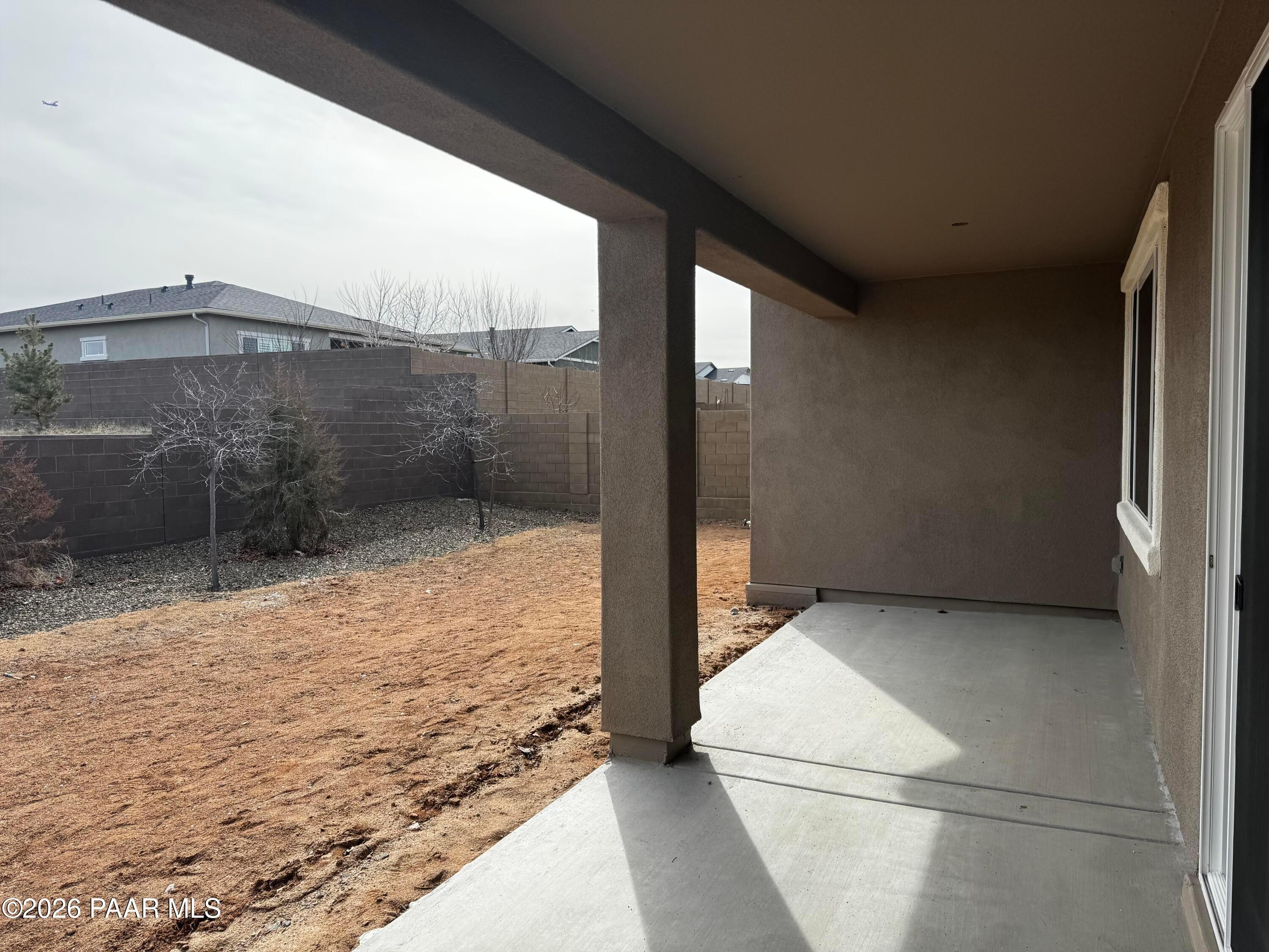 Covered patio with stucco walls, gravel backyard, and block fence in Davidson Homes The Durango II B, Westwood, Prescott, Arizona