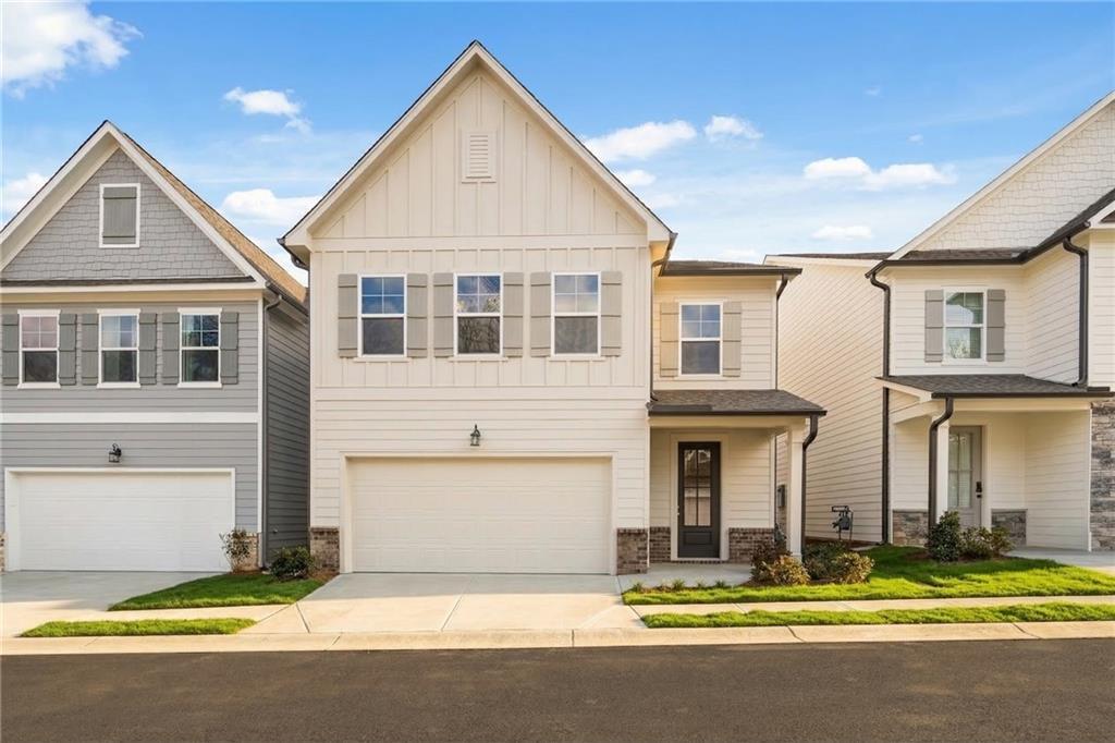 Modern 2-story white home with 2-car garage, shutters, and landscaped front yard in The Village at Shallowford, Kennesaw, Georgia