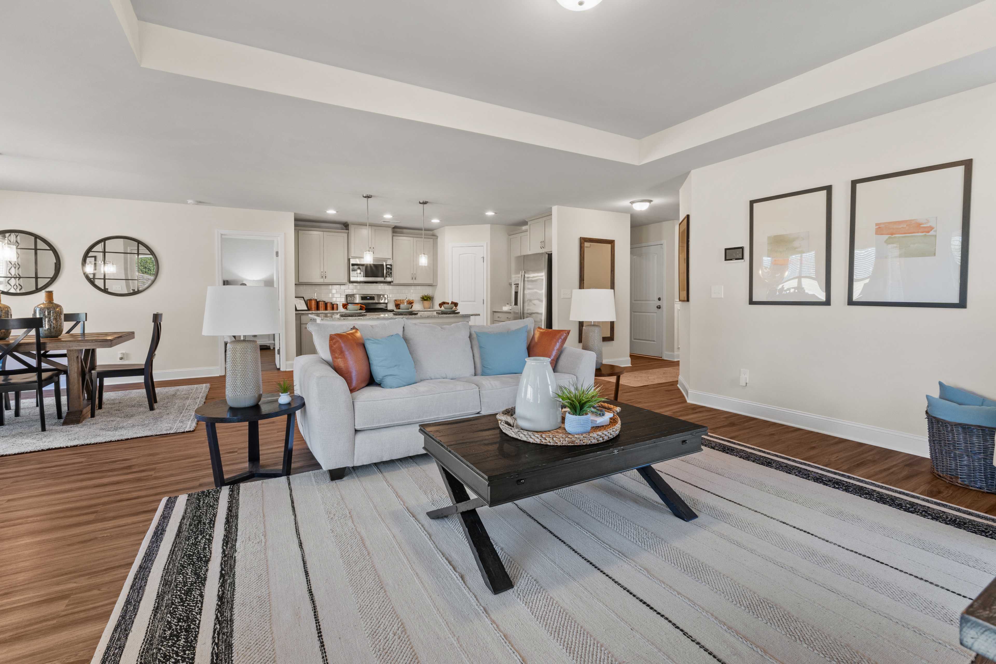 Spacious open-concept living room in Ramsay Cove, Owens Cross Roads AL with white sofa, hardwood floors, and modern kitchen