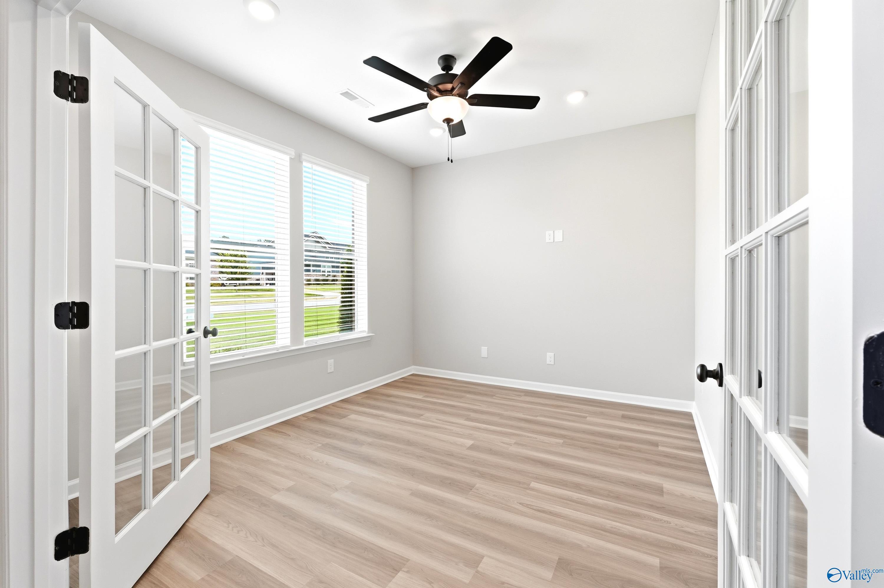 Bright home office with French doors and wood-look flooring in The Dorado floor plan at Riverton Preserve, Huntsville.