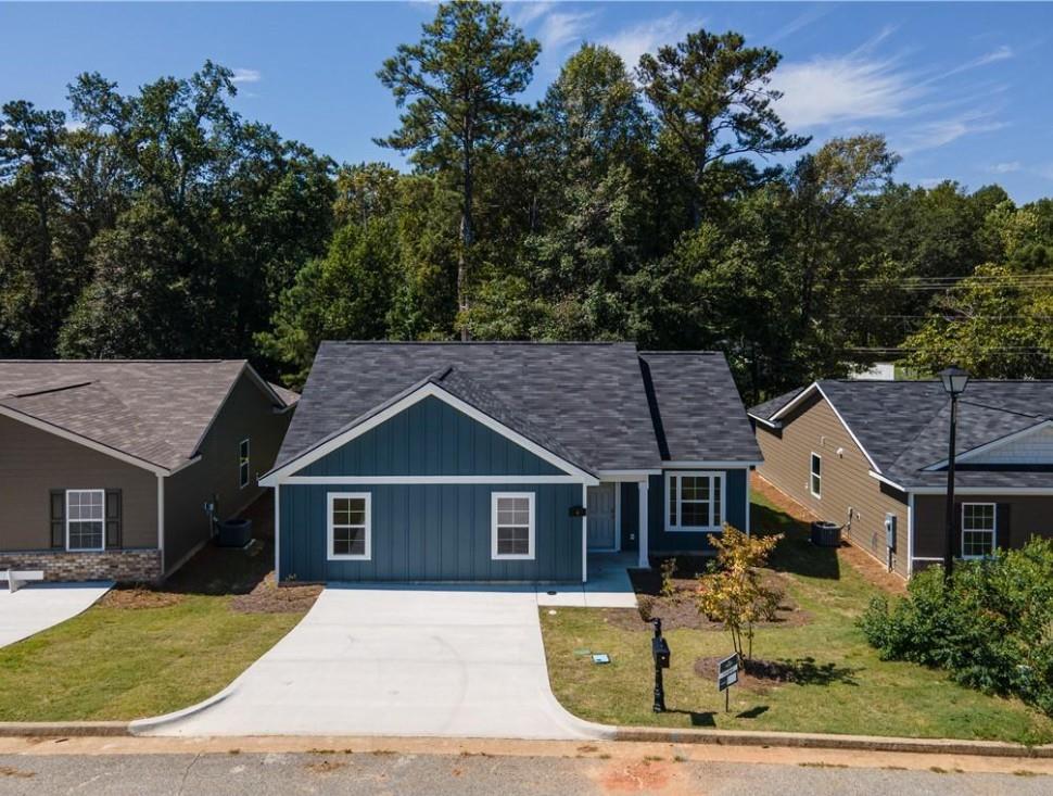 Navy blue 3-bedroom single-story home with white trim, driveway, and for-sale sign in Summer Vineyard, Phenix City, Alabama by Davidson Homes
