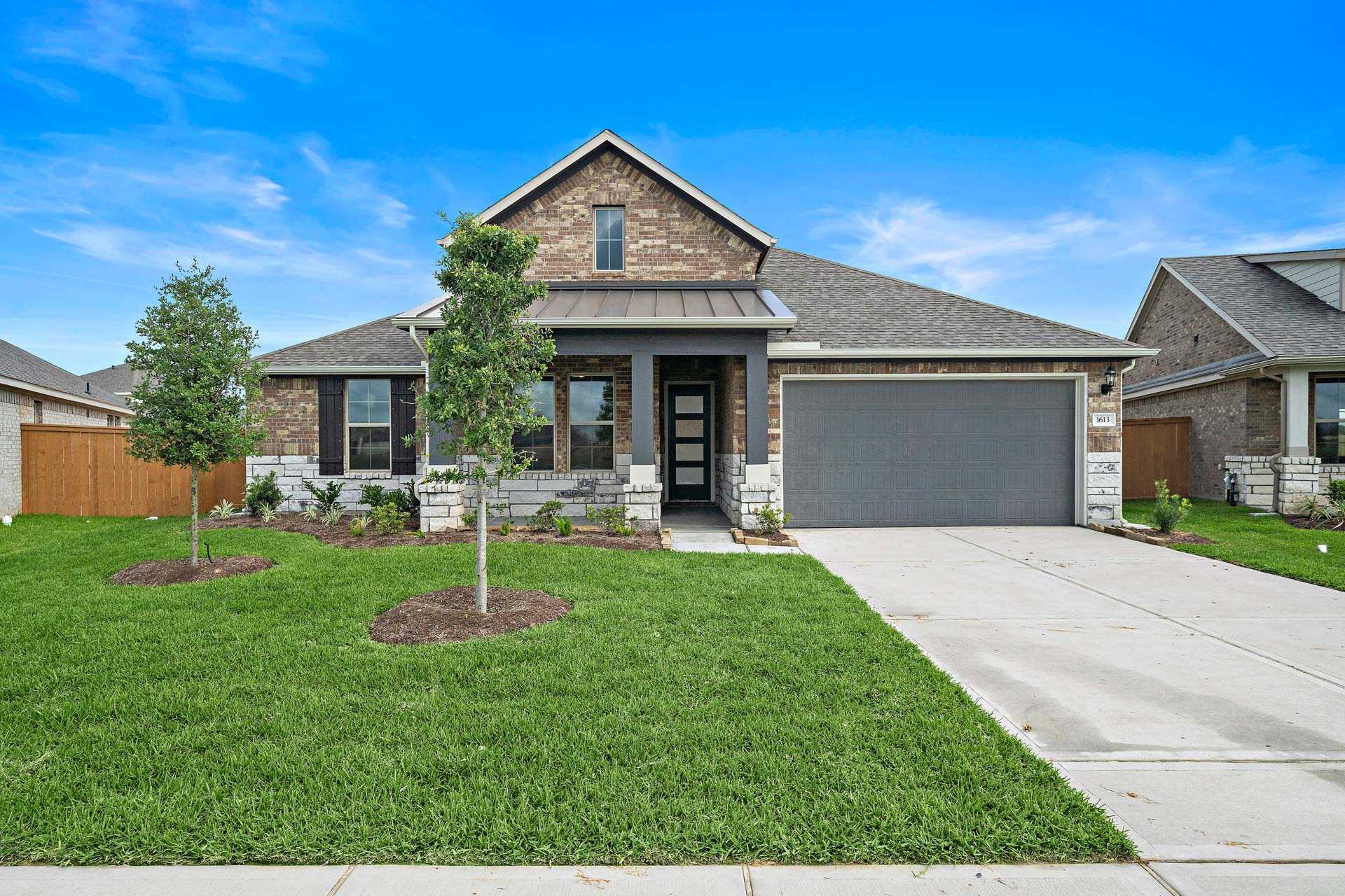 Modern brick home exterior at Sierra Vista in Rosharon Texas with covered entry garage and landscaped yard