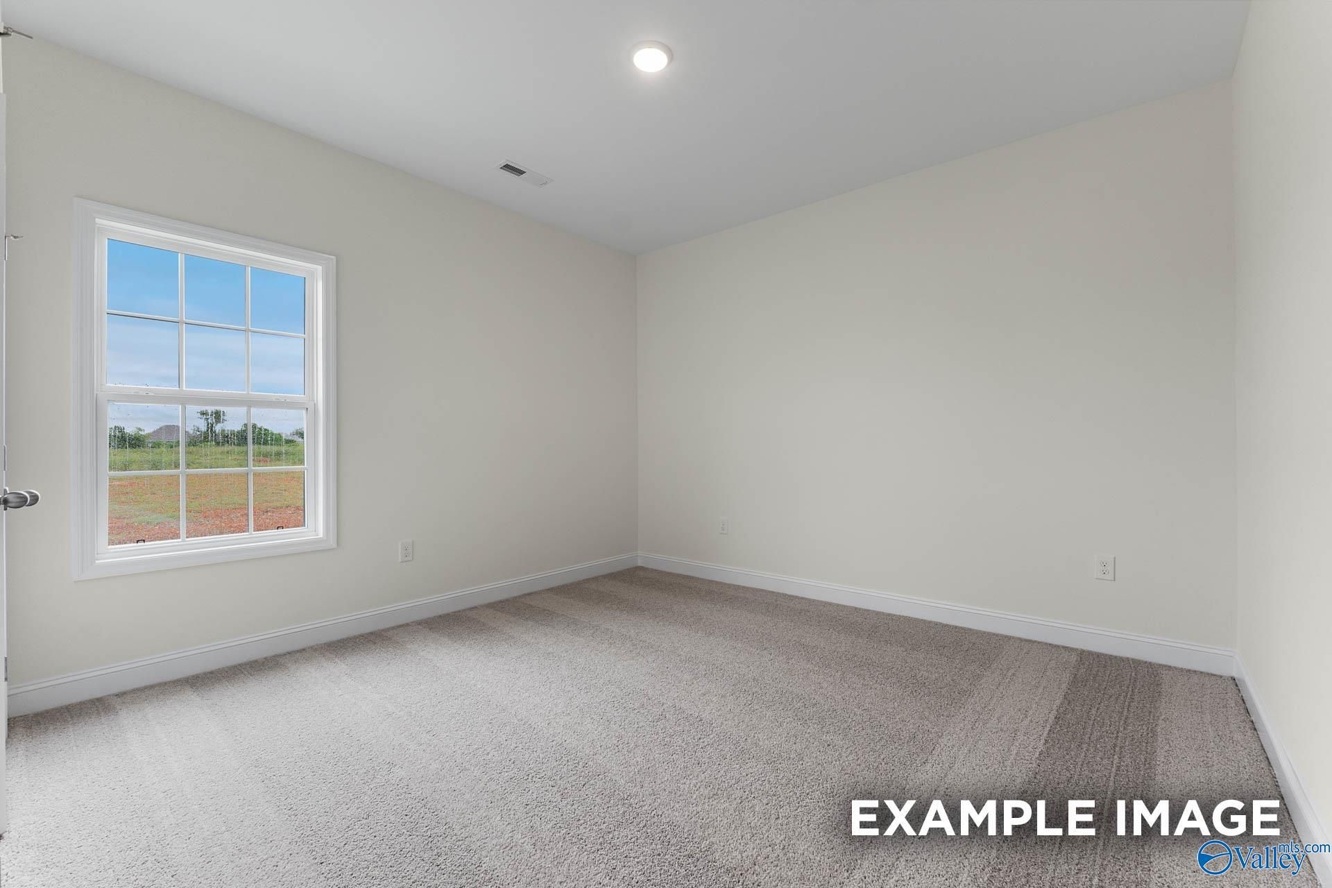 Bright empty bedroom with large window overlooking field in The Emory 4-bedroom home, Davidson Homes, Toney, Alabama