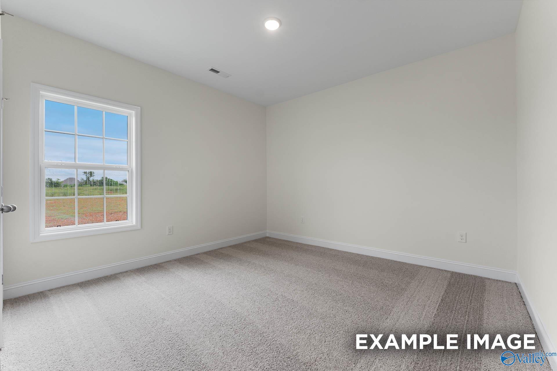 Bright empty bedroom with large window overlooking field in The Emory 4-bedroom home, Davidson Homes, Toney, Alabama