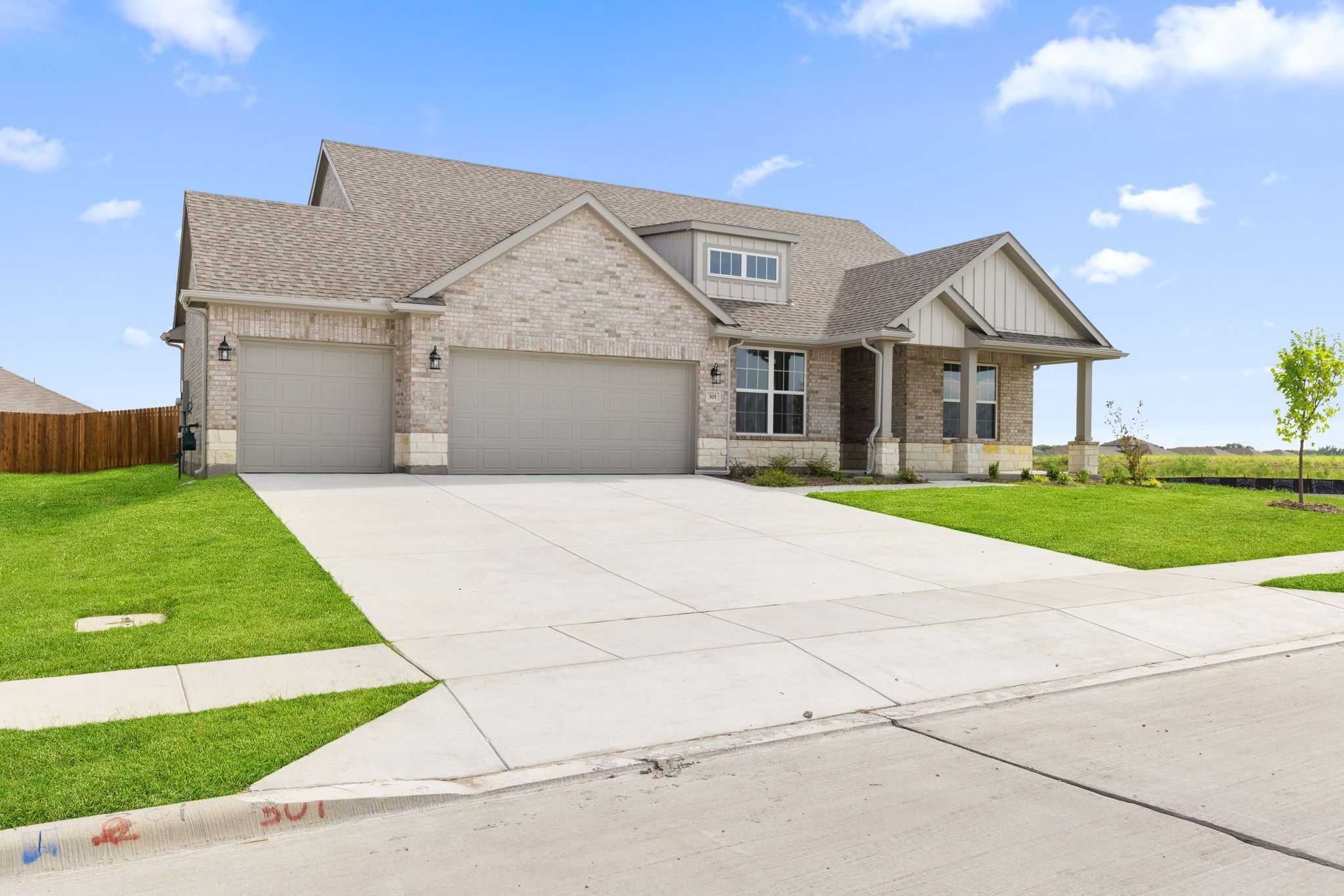 Modern 1-story tan brick home with 3-car garage, shingled roof, and landscaped lawn in Waverly Estates, Josephine, Texas - The Harrison D by Davidson Homes