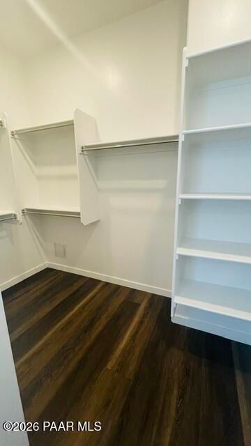 Walk-in closet with built-in shelving and wood-style flooring in The Aurea C floor plan, Hidden Hills, Prescott, Arizona.