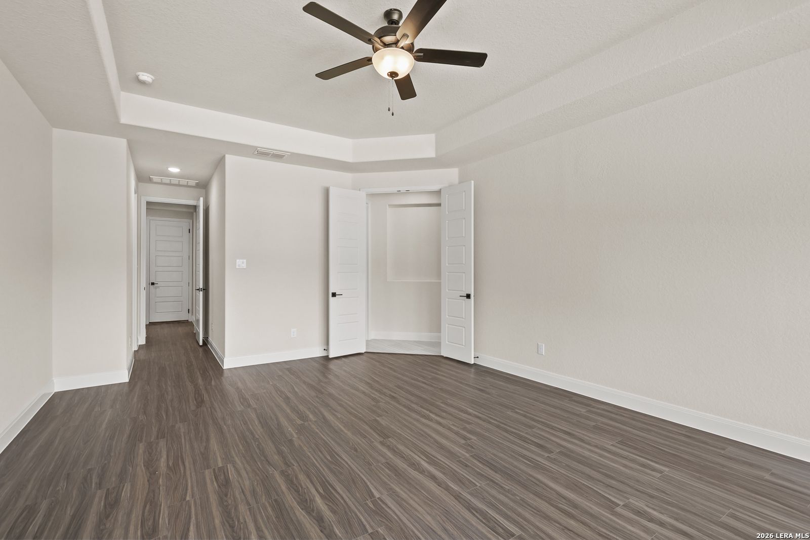 Spacious bedroom with tray ceiling and closet in The Summerlin B floor plan by Davidson Homes in Potranco Oaks, Castroville.