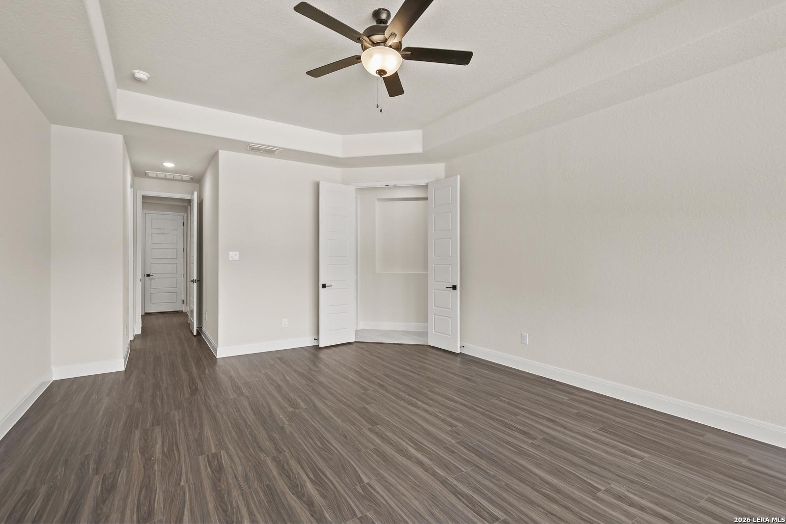 Spacious bedroom with tray ceiling and closet in The Summerlin B floor plan by Davidson Homes in Potranco Oaks, Castroville.