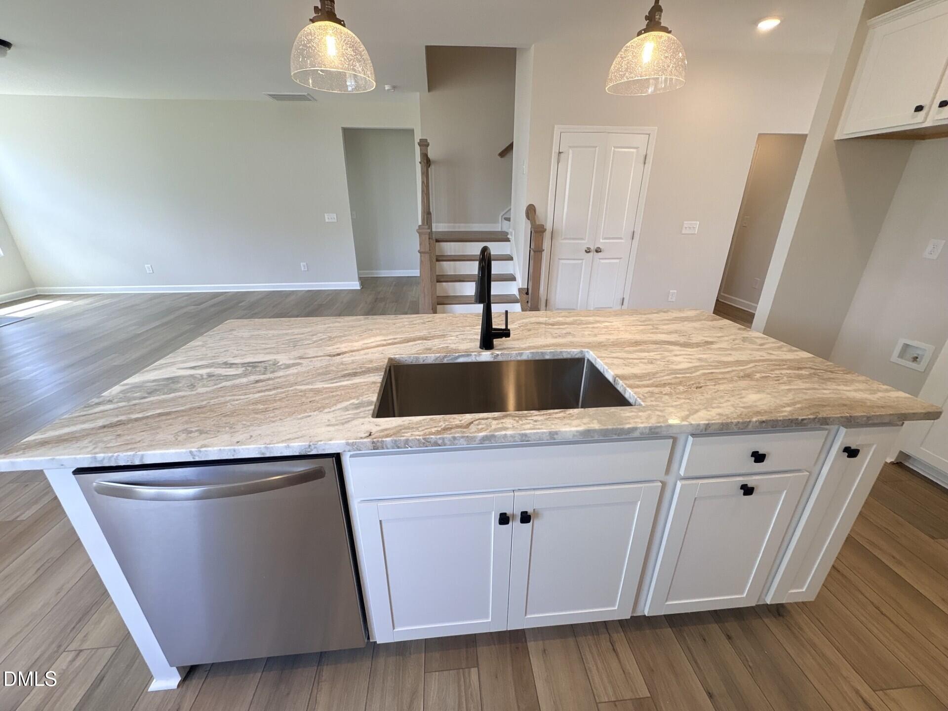 Modern kitchen island with granite countertops in The Ash C floor plan by Davidson Homes in Woodland Crossing, Zebulon, NC.