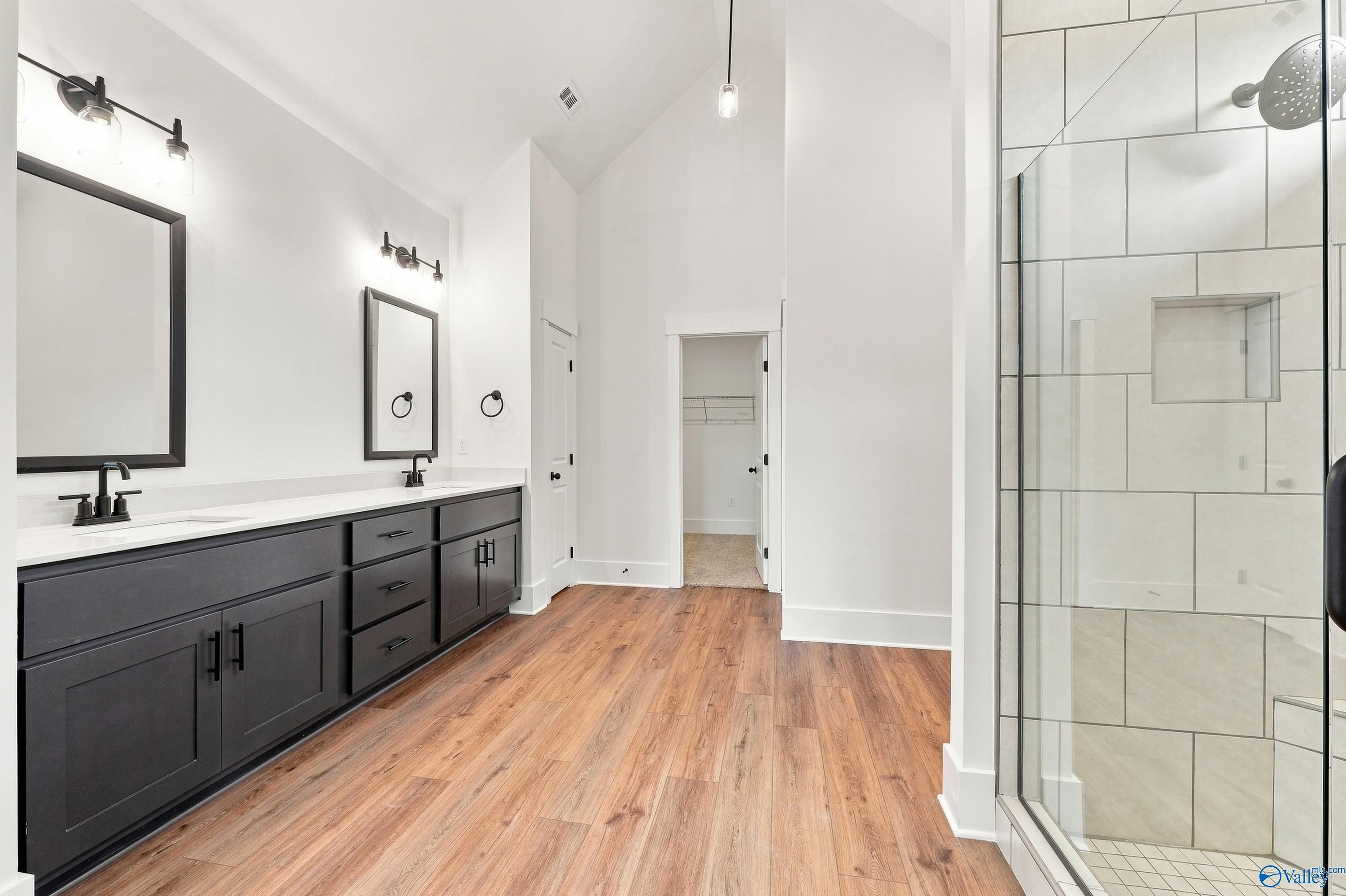 Modern primary bathroom with double vanity and walk-in shower in The Valencia floor plan at Riverton Preserve, Huntsville.