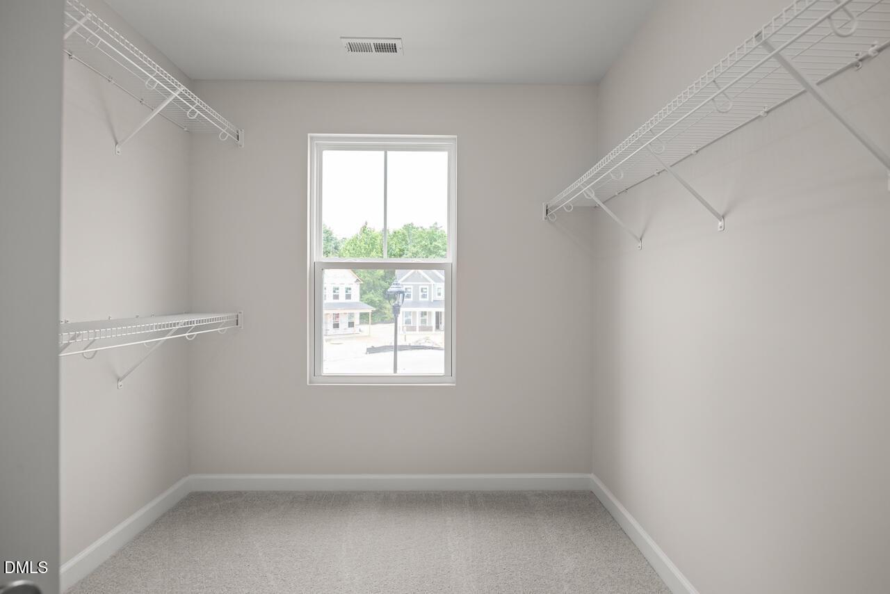 Walk-in closet with wire shelving in The Willow B floor plan at Woodland Crossing in Zebulon, North Carolina.