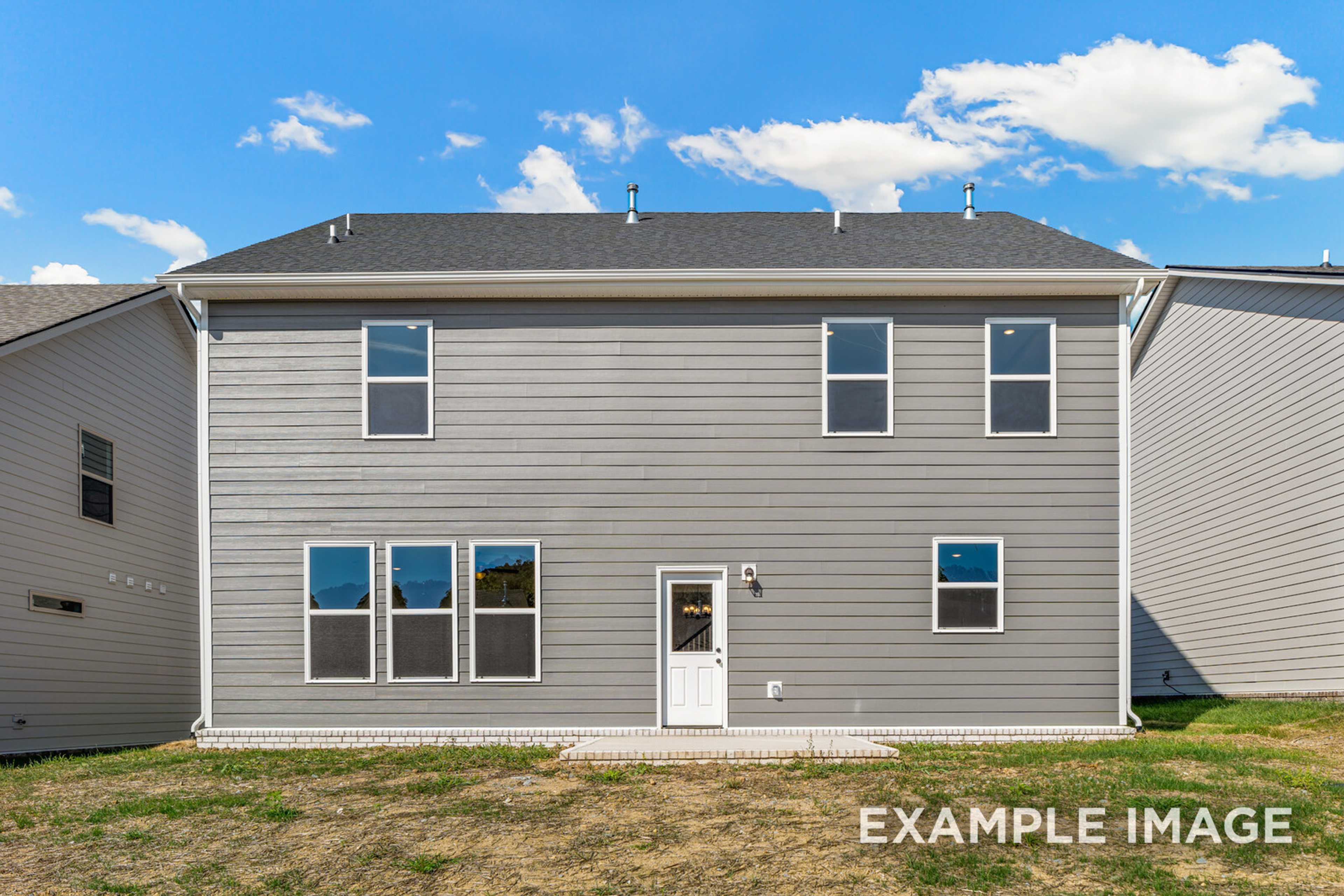 Rear elevation of The Henry C two-story home with gray siding, large windows, and patio door in Mt. Juliet