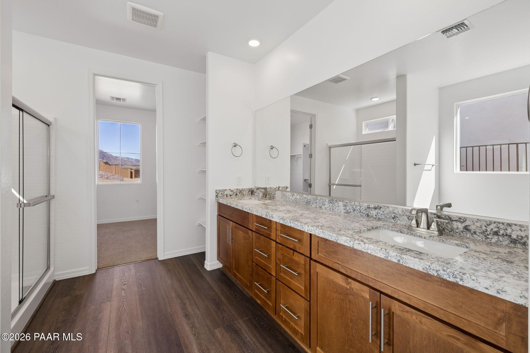 Modern master bathroom with double granite vanity, wood cabinets, walk-in shower, and mountain view in The Monarch A, Prescott AZ