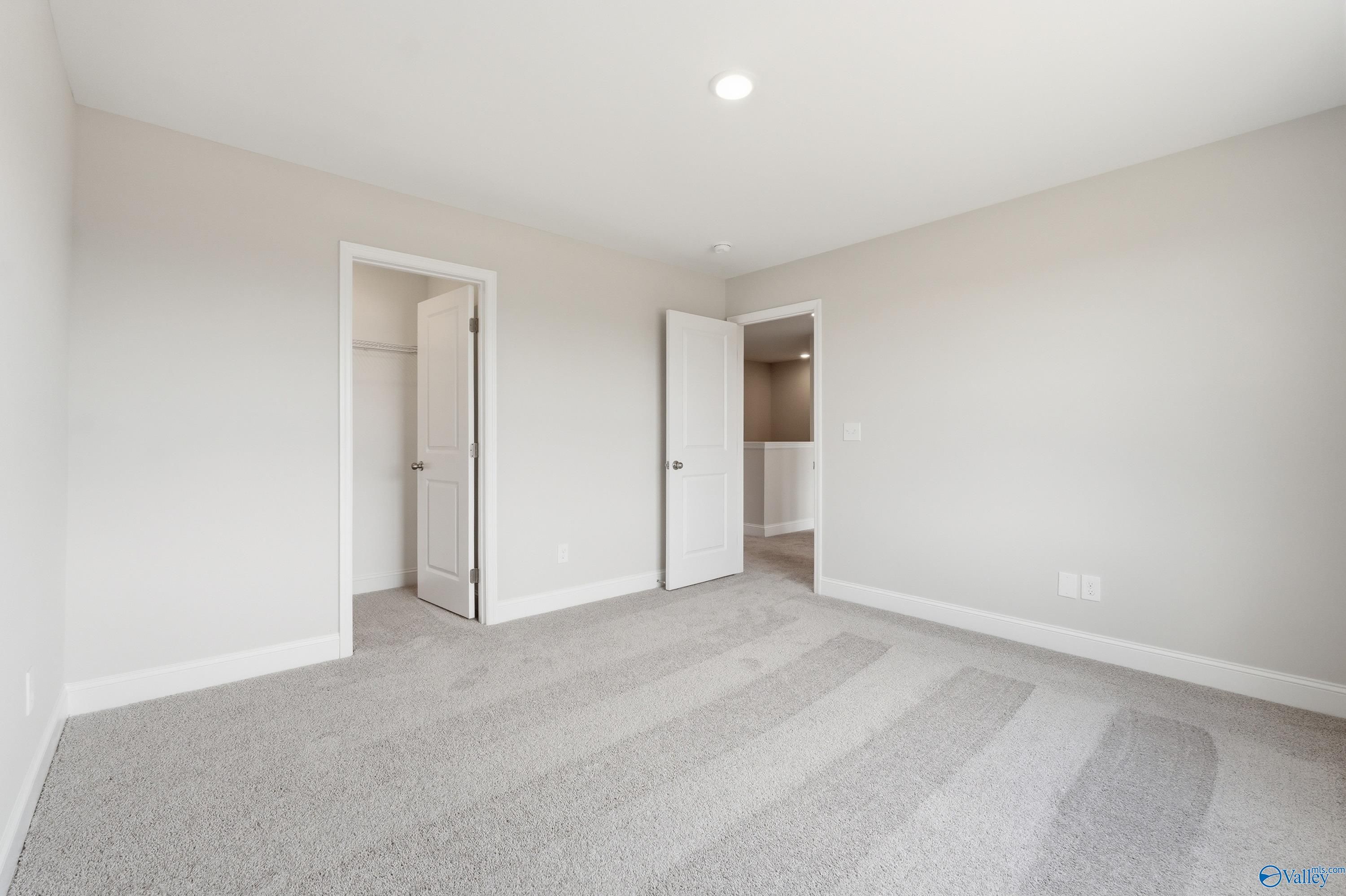 Spacious secondary bedroom with walk-in closet and en-suite bath in Davidson Homes The Shelby B, Creek Grove, New Market, Alabama