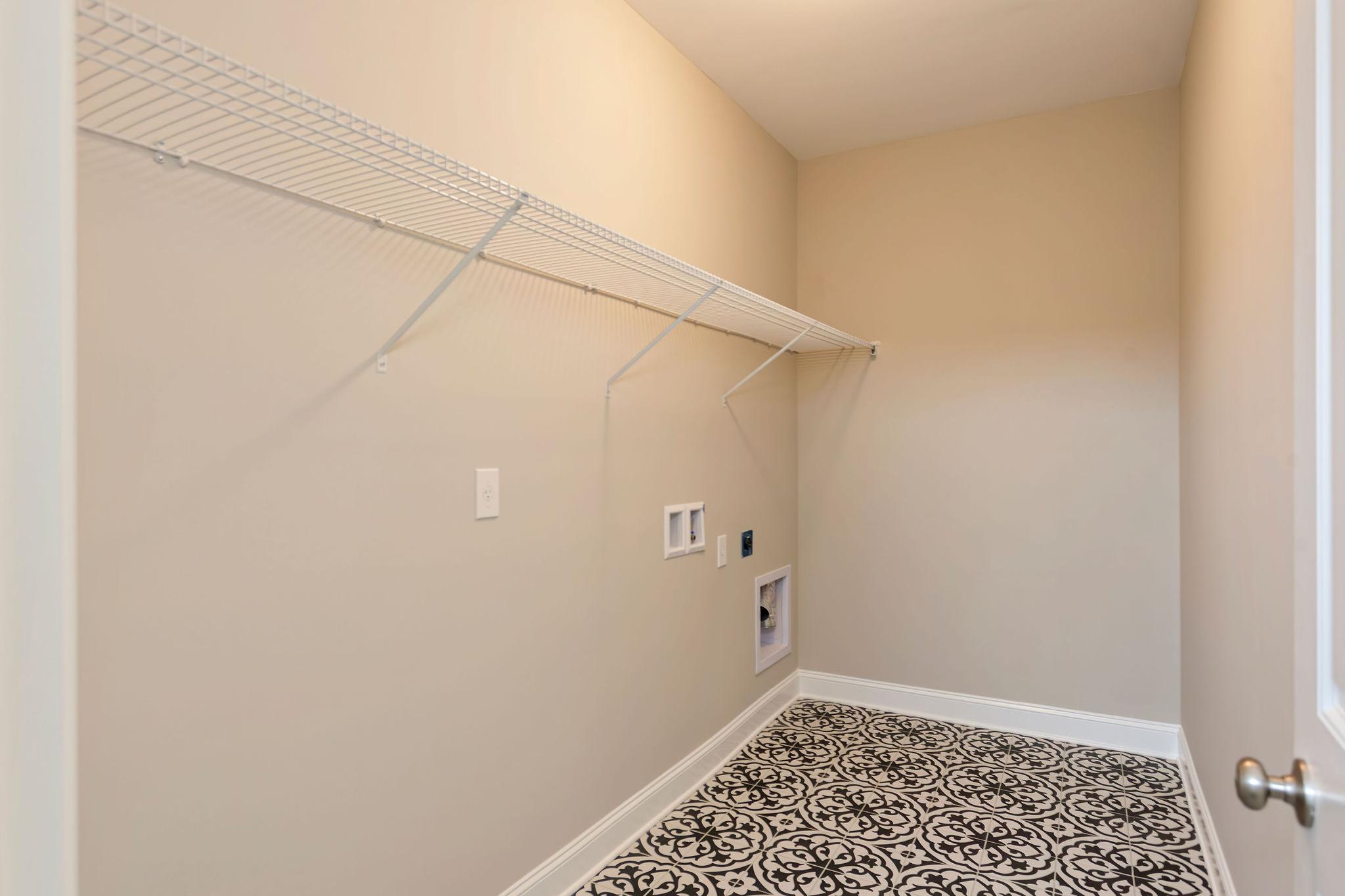 Davidson Homes The Emory Floor Plan Unfurnished Laundry Room with patterned tile floors and wall shelving
