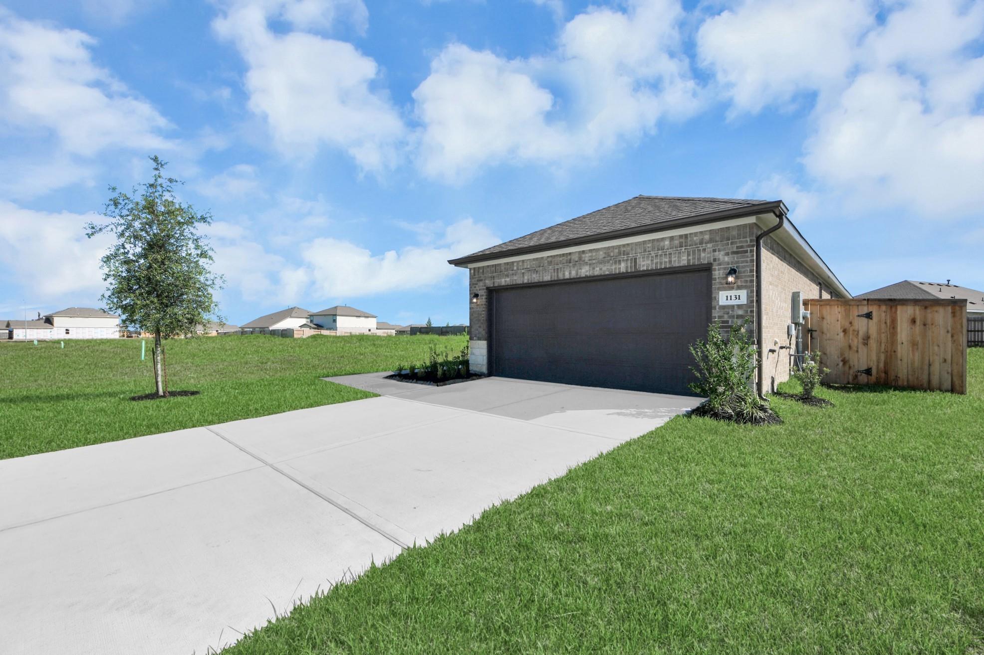 Brick exterior and 2-car garage of The Colorado G floor plan by Davidson Homes in Emberly, Beasley, Texas.
