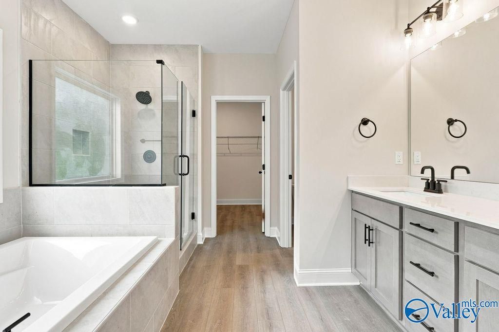Modern master bathroom with garden tub, glass shower, and double vanity in Davidson Homes' Rockford plan, Cain Park, Hartselle