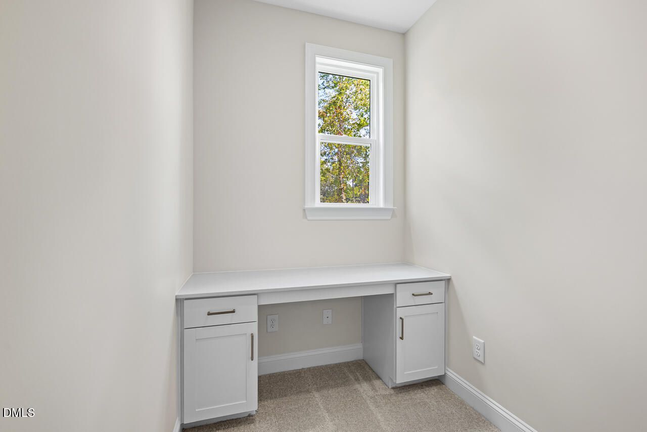 Built-in white desk with cabinets beneath window in flex office space of Davidson Homes Crawford D plan, Wake Forest, NC