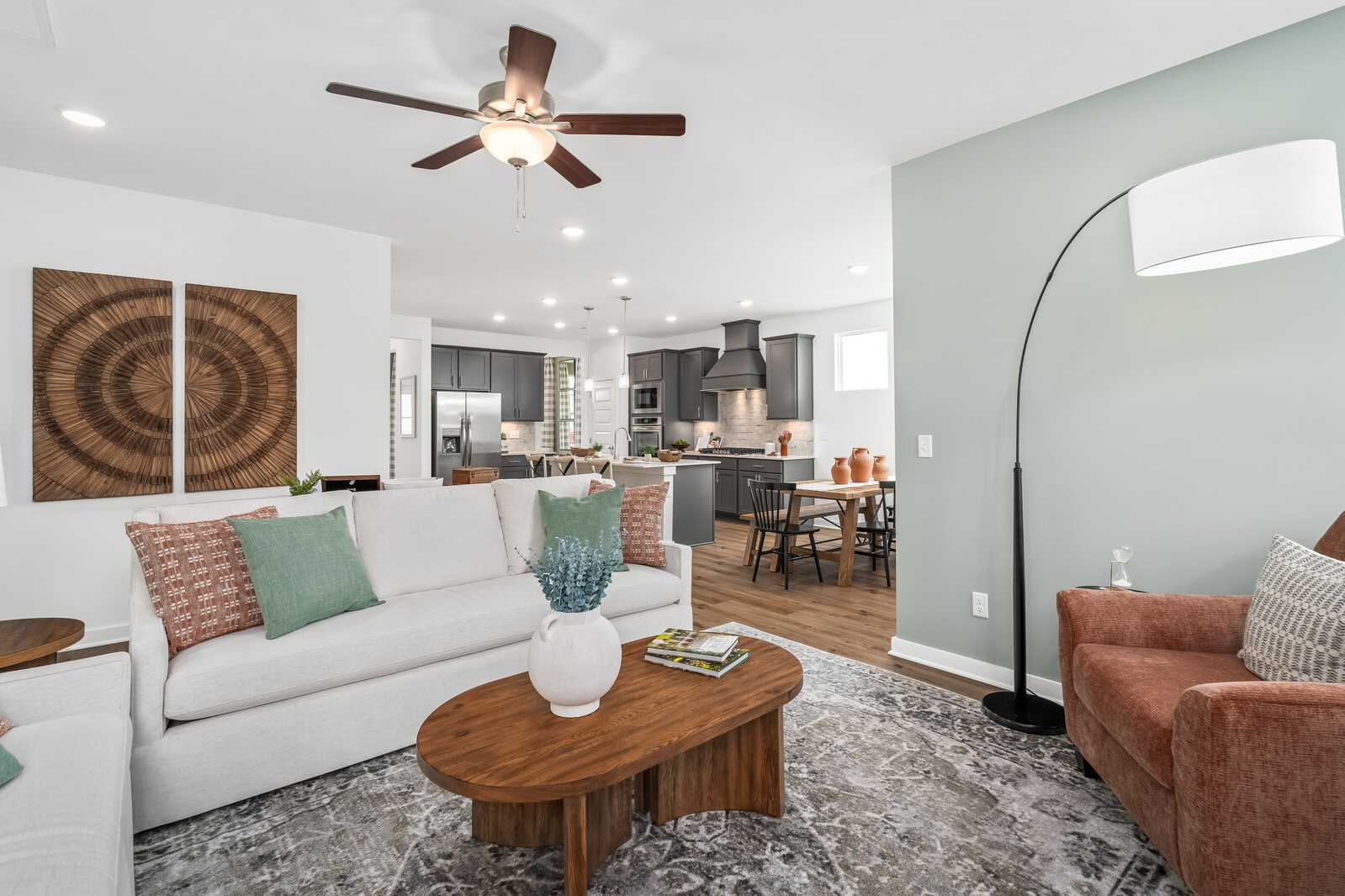 Spacious open-concept living room at Calista Farms in White House TN with white sofa, wooden coffee table, and adjacent modern kitchen