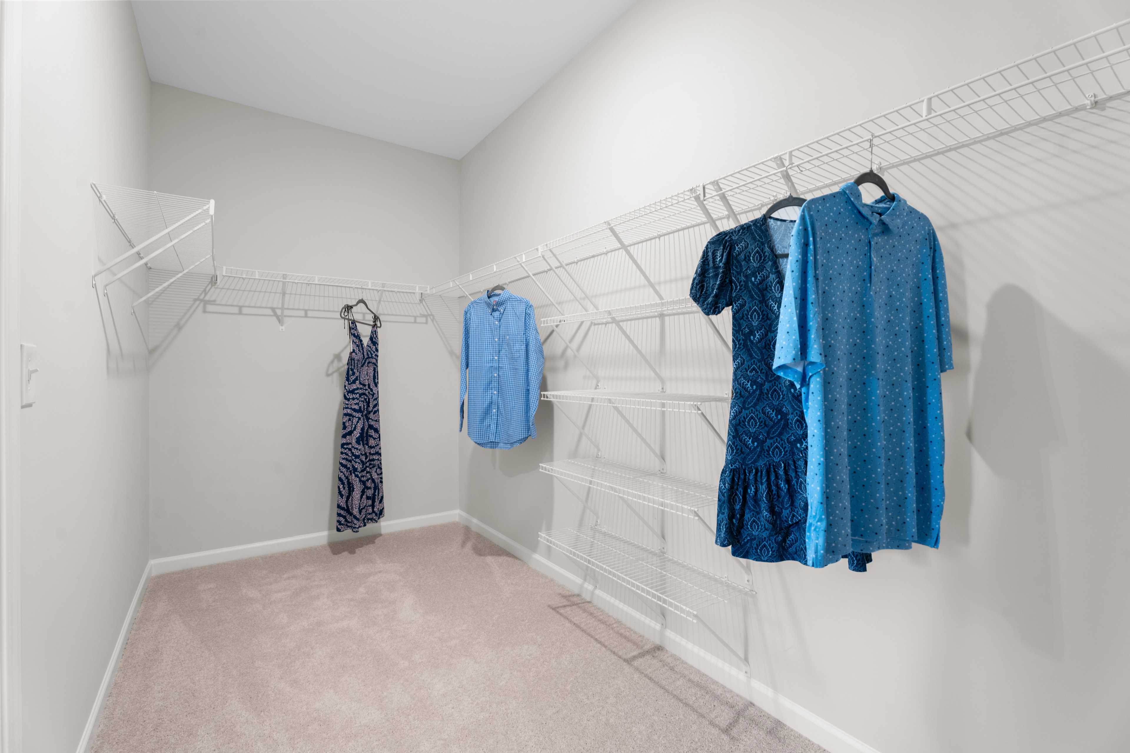 large owners suite closet with shoe racks and a few hanging clothes