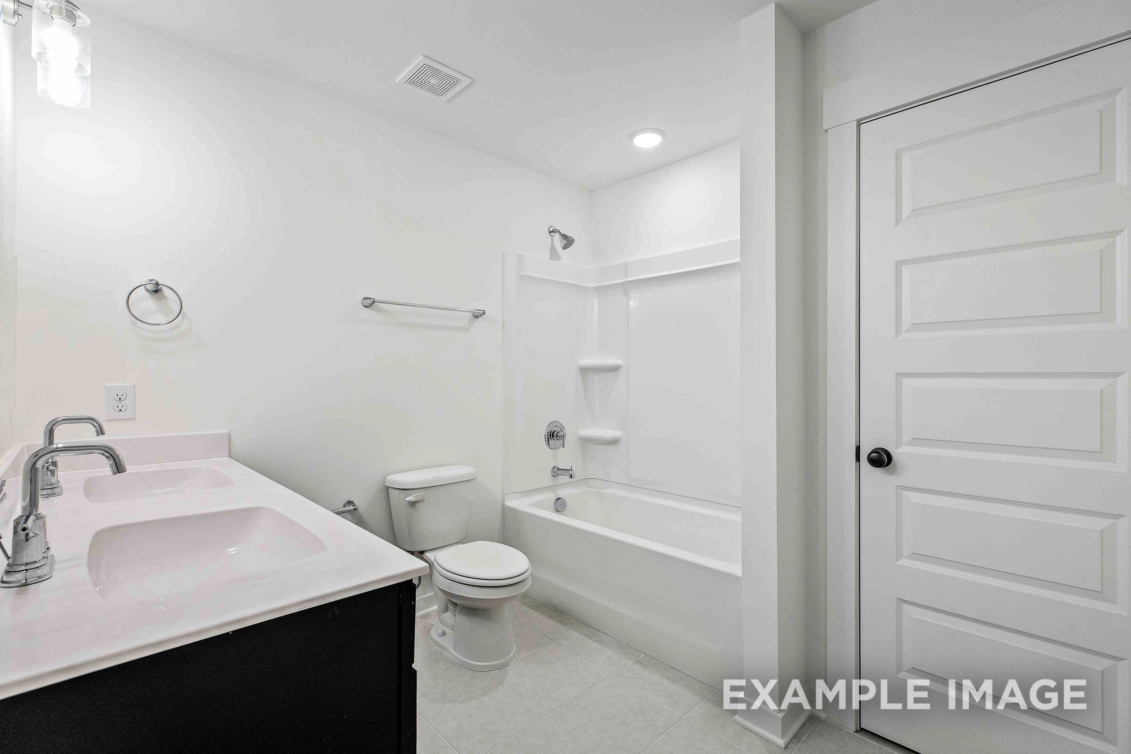 Spacious master bathroom in The Charleston home with double vanity, soaking tub, and walk-in shower
