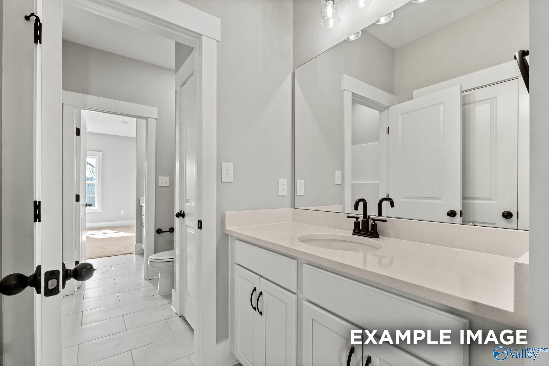 Modern bathroom with white vanity, quartz countertop, and tile flooring in The Finleigh plan at Briercreek, Meridianville.